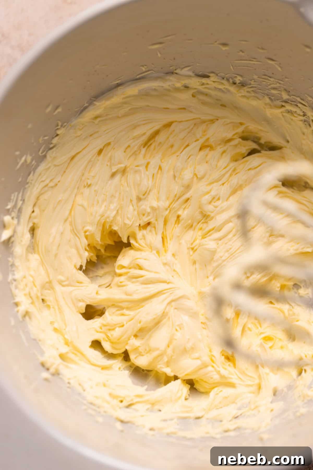 Whipped egg yolks and mascarpone cheese in a bowl, forming a rich tiramisu cream.