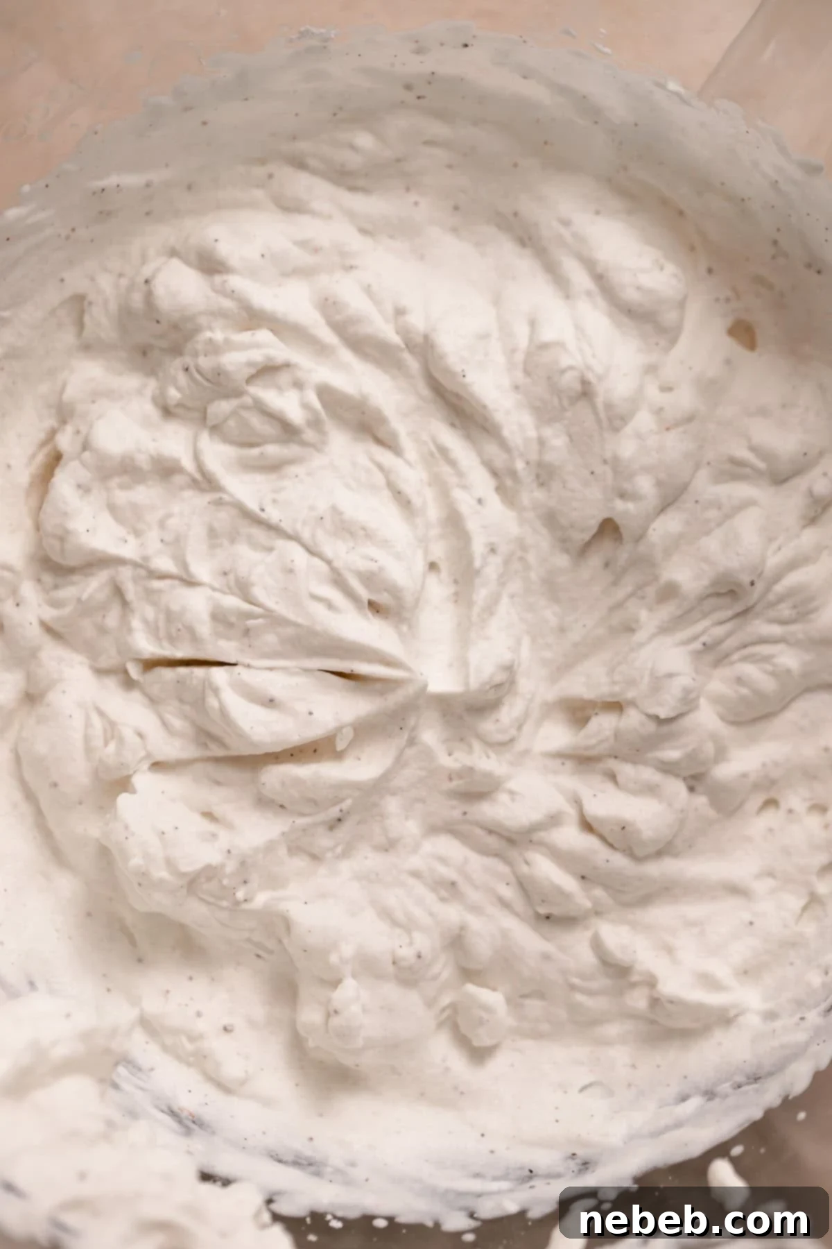 Freshly whipped cream with medium peaks, in a large mixing bowl.