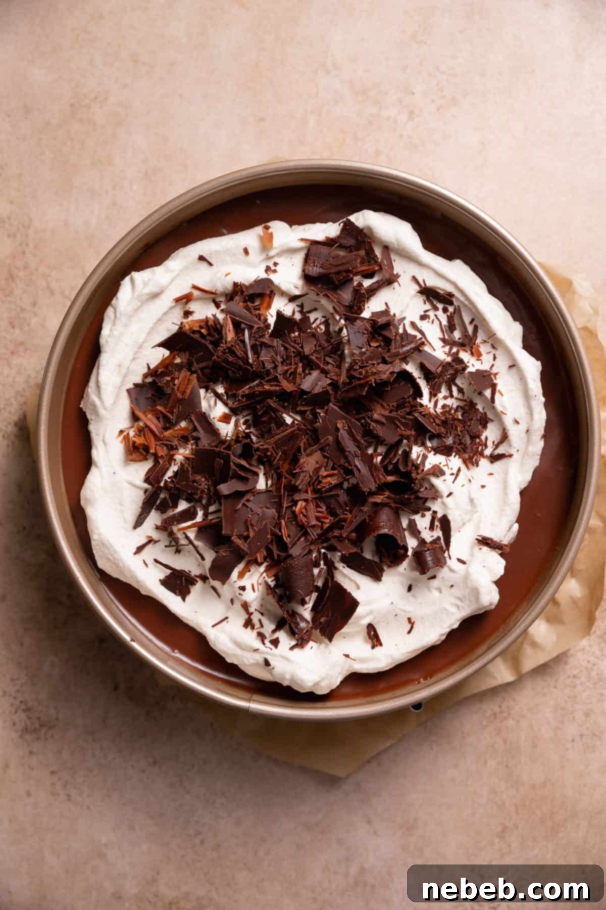 The finished dark chocolate mousse pie, beautifully garnished with swirls of homemade whipped cream and delicate chocolate curls.