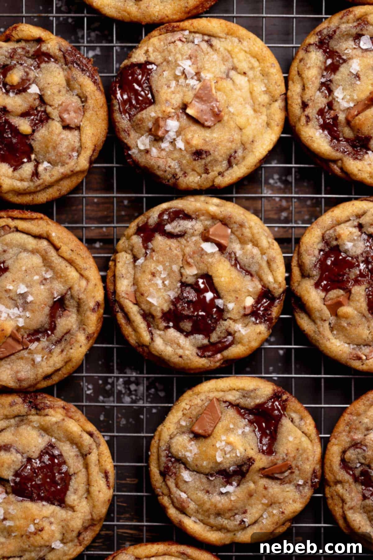 Brown butter chocolate chunk cookies on a wire rack sprinkled with sea salt.