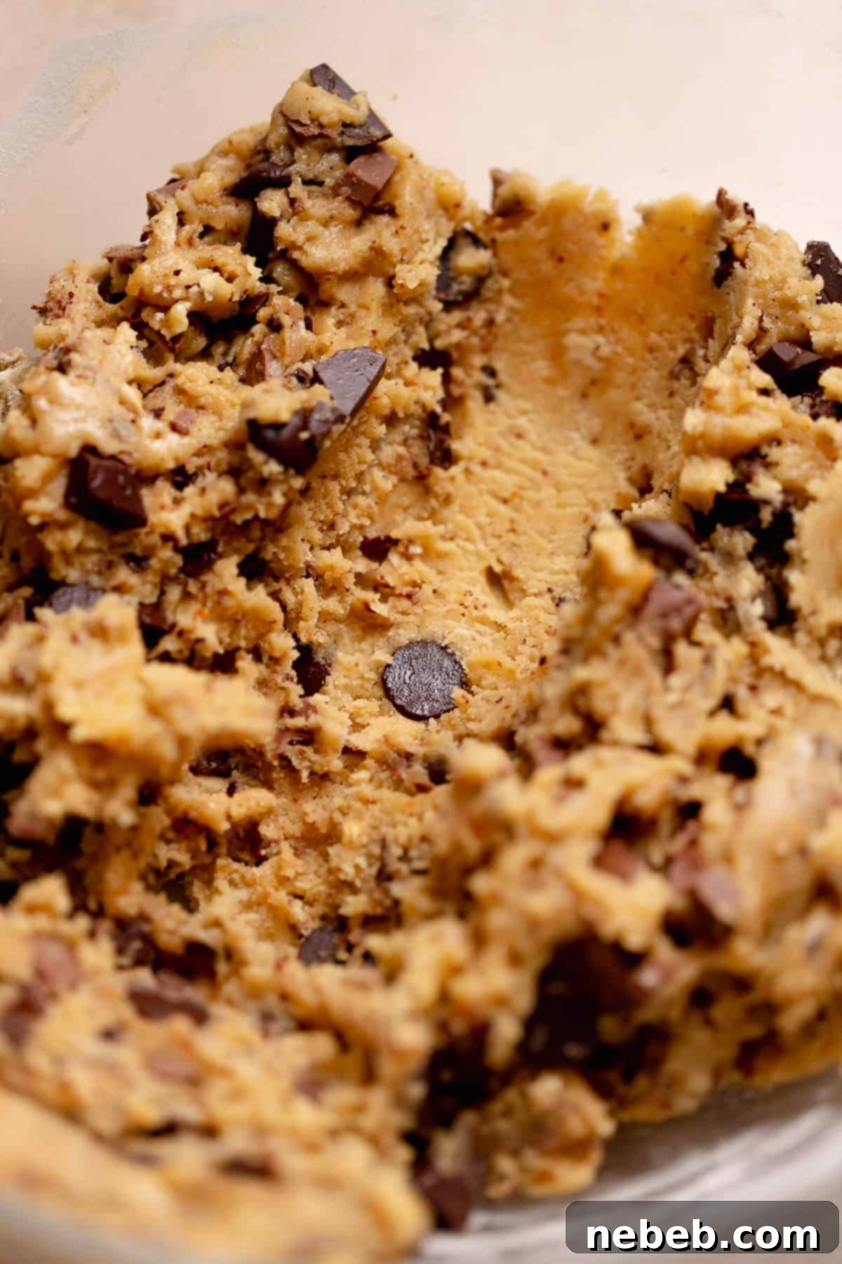 A close up of a line of scooped cookie dough in the glass bowl.