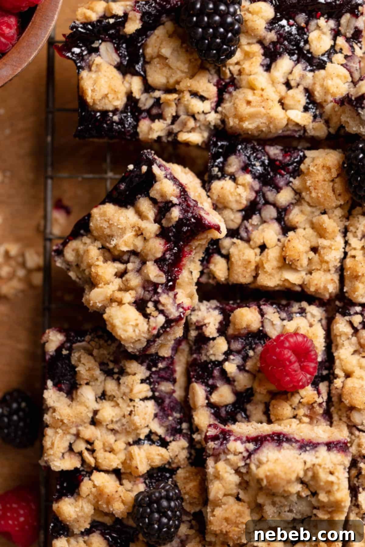 Mixed berry crumb bar with a bite taken out of it, showcasing the juicy berry filling and crumbly topping.