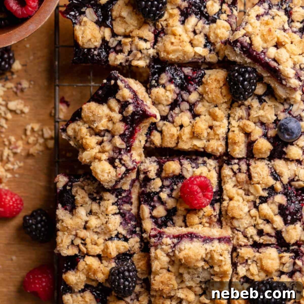 Brown sugar berry crumble bars topped with fresh raspberries, blackberries, and blueberries.