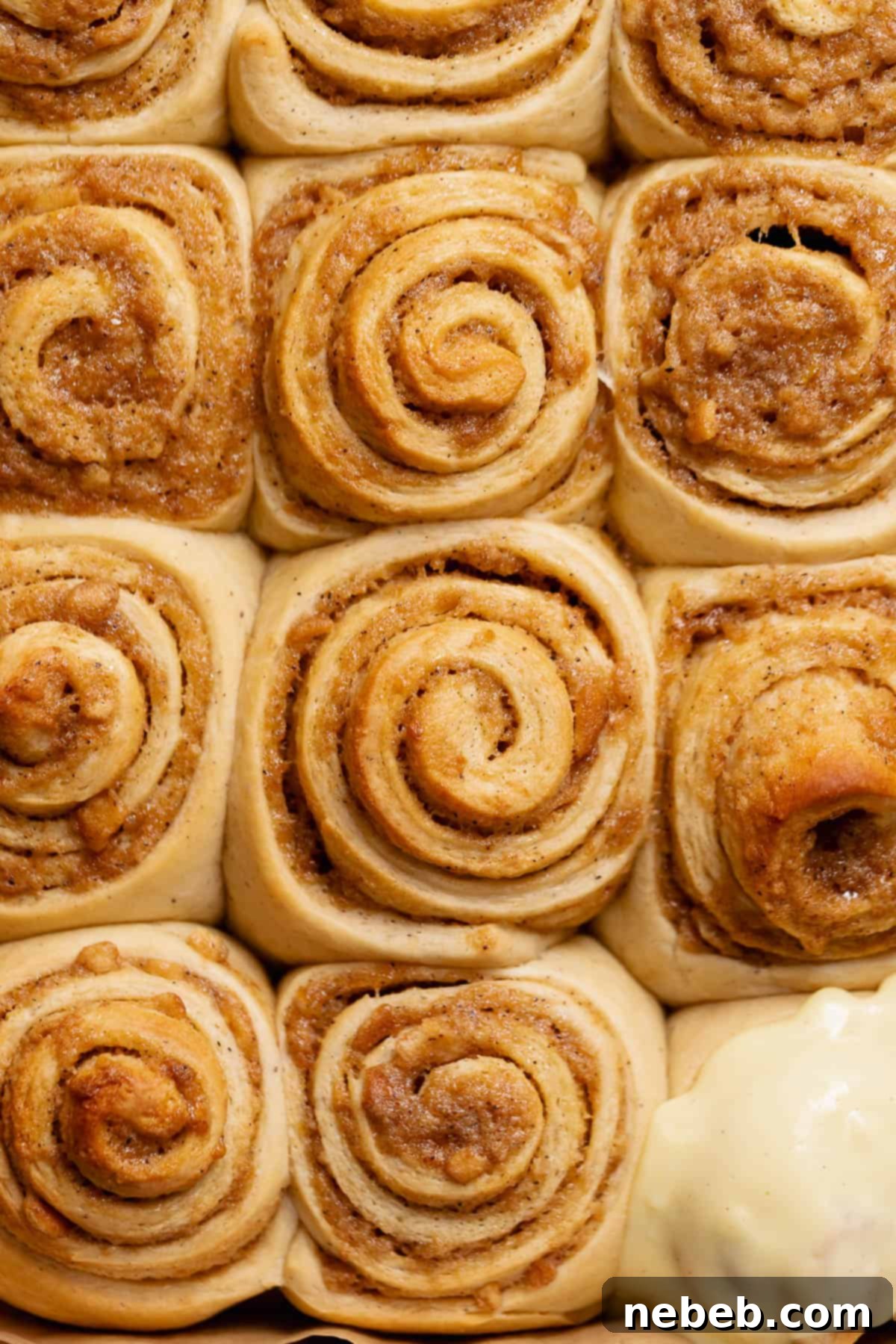 Decadent Banana Pudding Cinnamon Rolls 11 Banana pudding buns with golden brown tops after baking, still in the pan.
