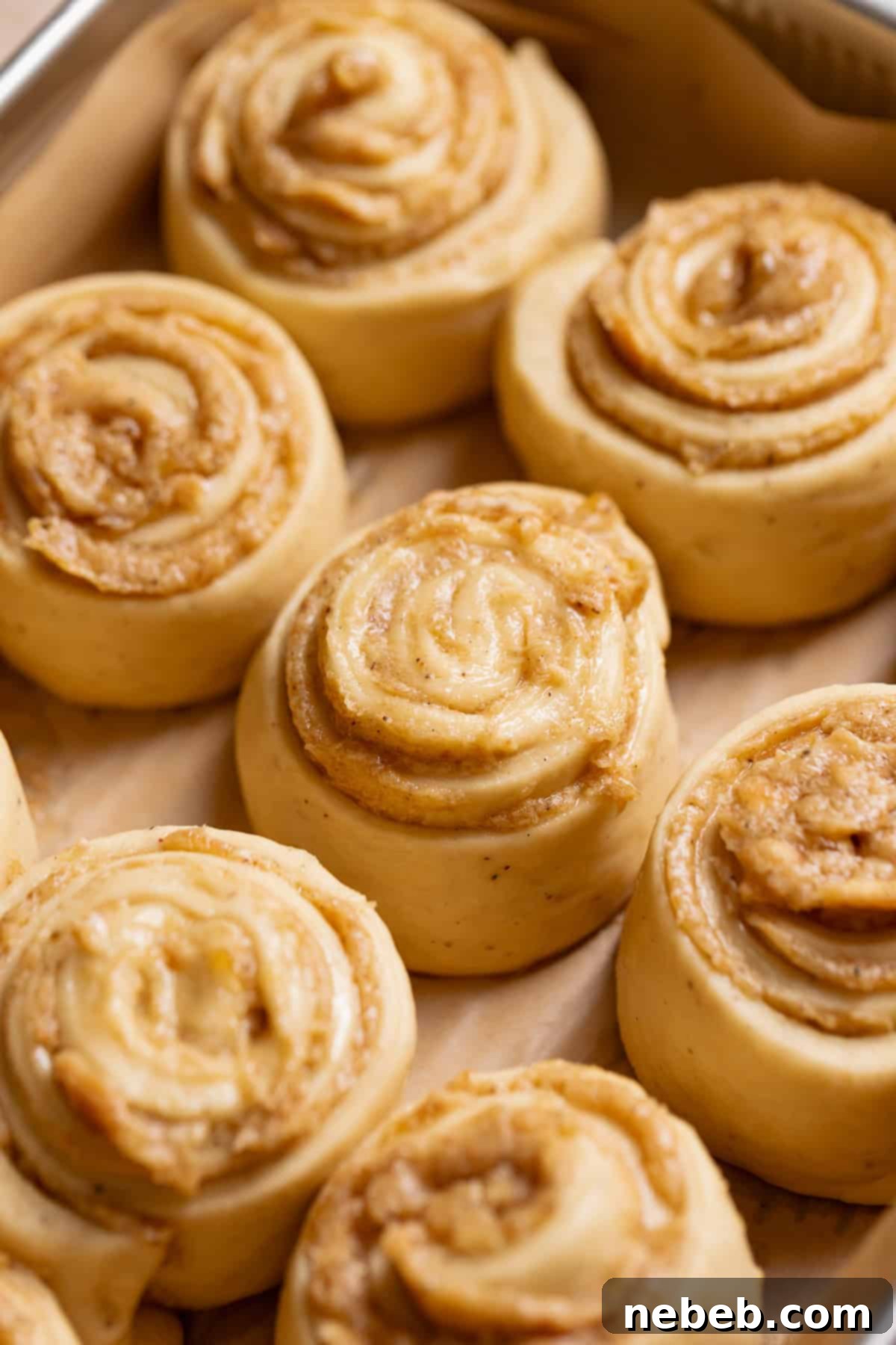 Decadent Banana Pudding Cinnamon Rolls 10 Banana pudding rolls in a baking pan, having doubled in size after rising.