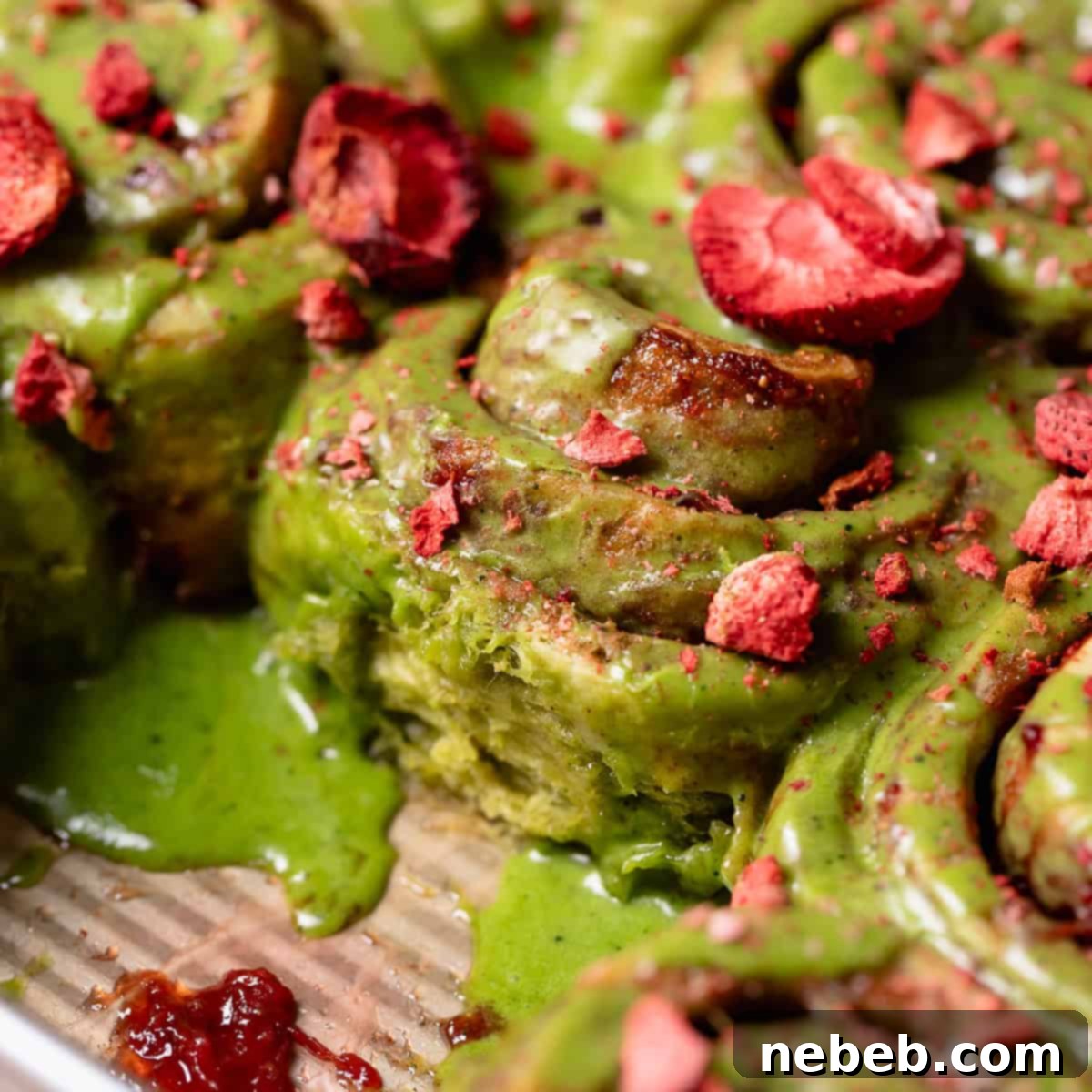 Strawberry matcha cinnamon rolls in a baking pan.