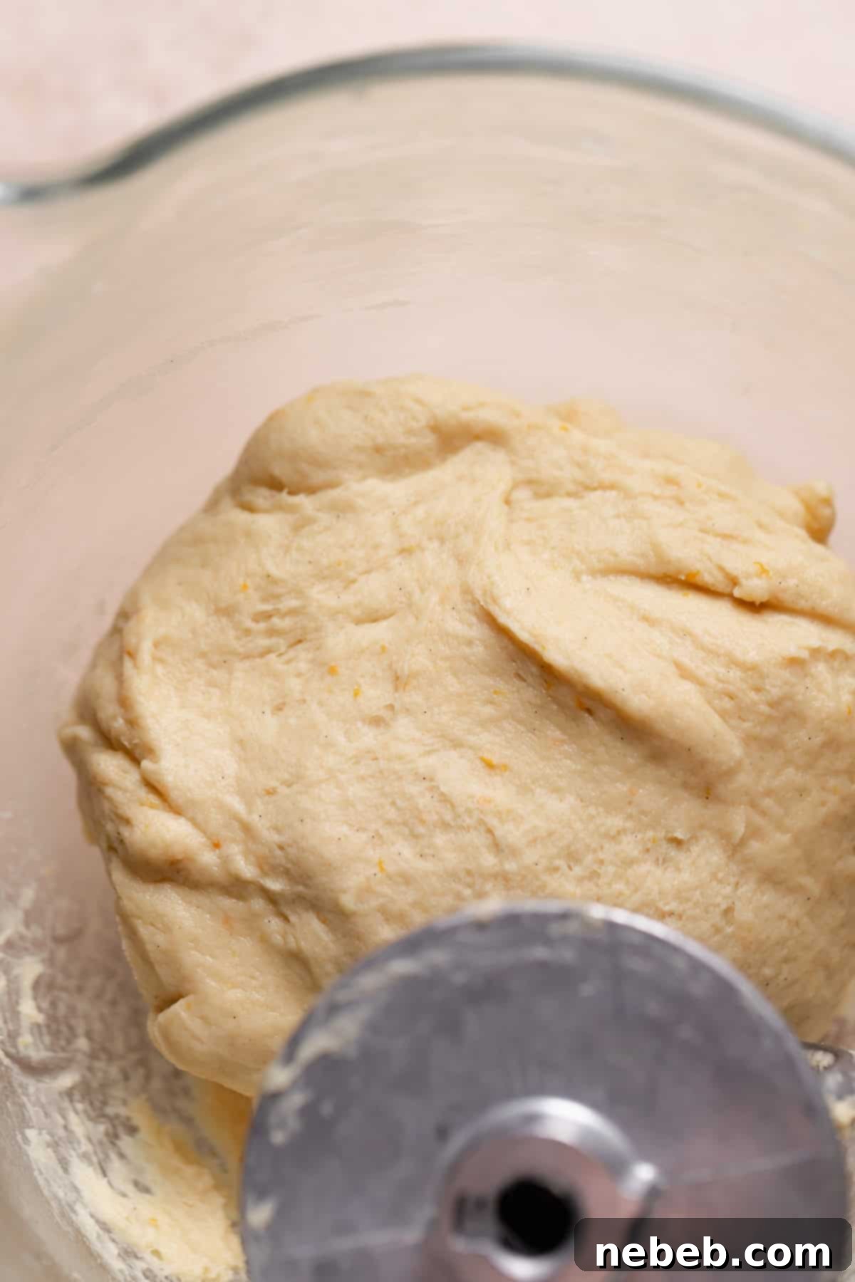 Soft, kneaded orange zest dough in a mixer bowl.