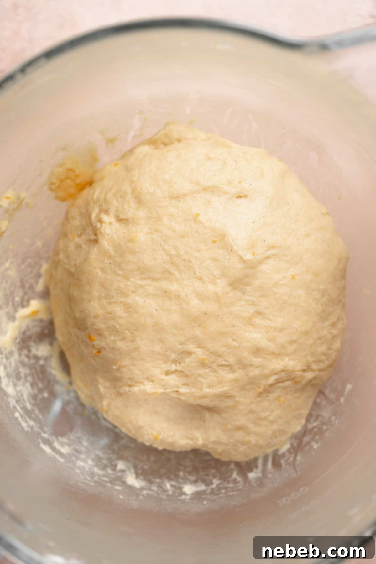 A shaped dough ball resting in a glass bowl.