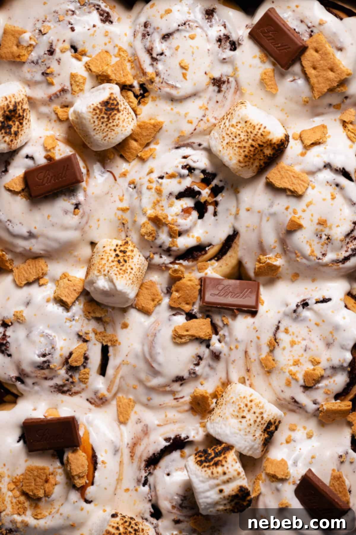 An overhead shot of the smores rolls topped with marshmallow glaze and toasted marshmallows, garnished with chocolate and graham cracker crumbs.