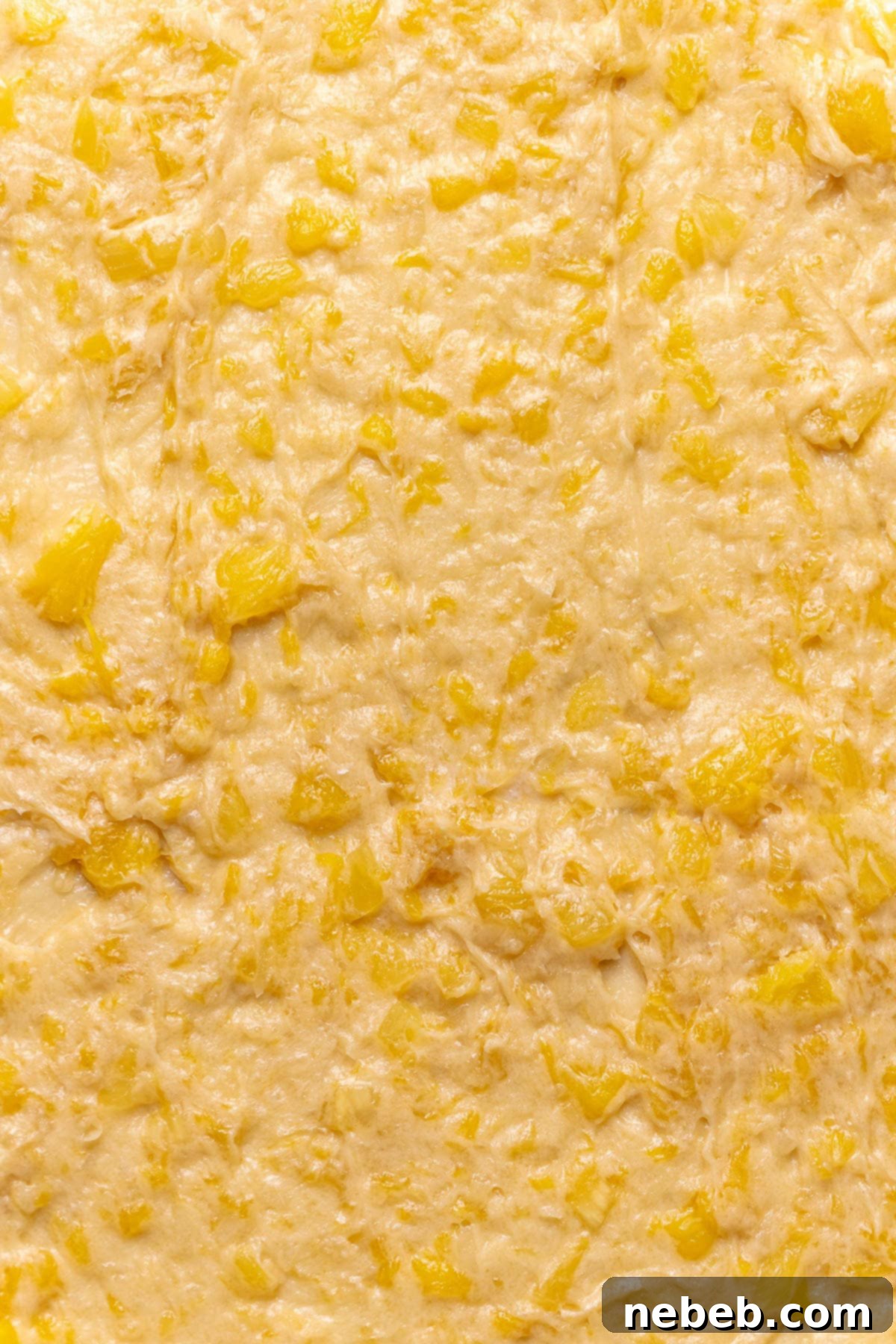 Pineapple coconut filling spread out onto rolled out cinnamon roll dough.