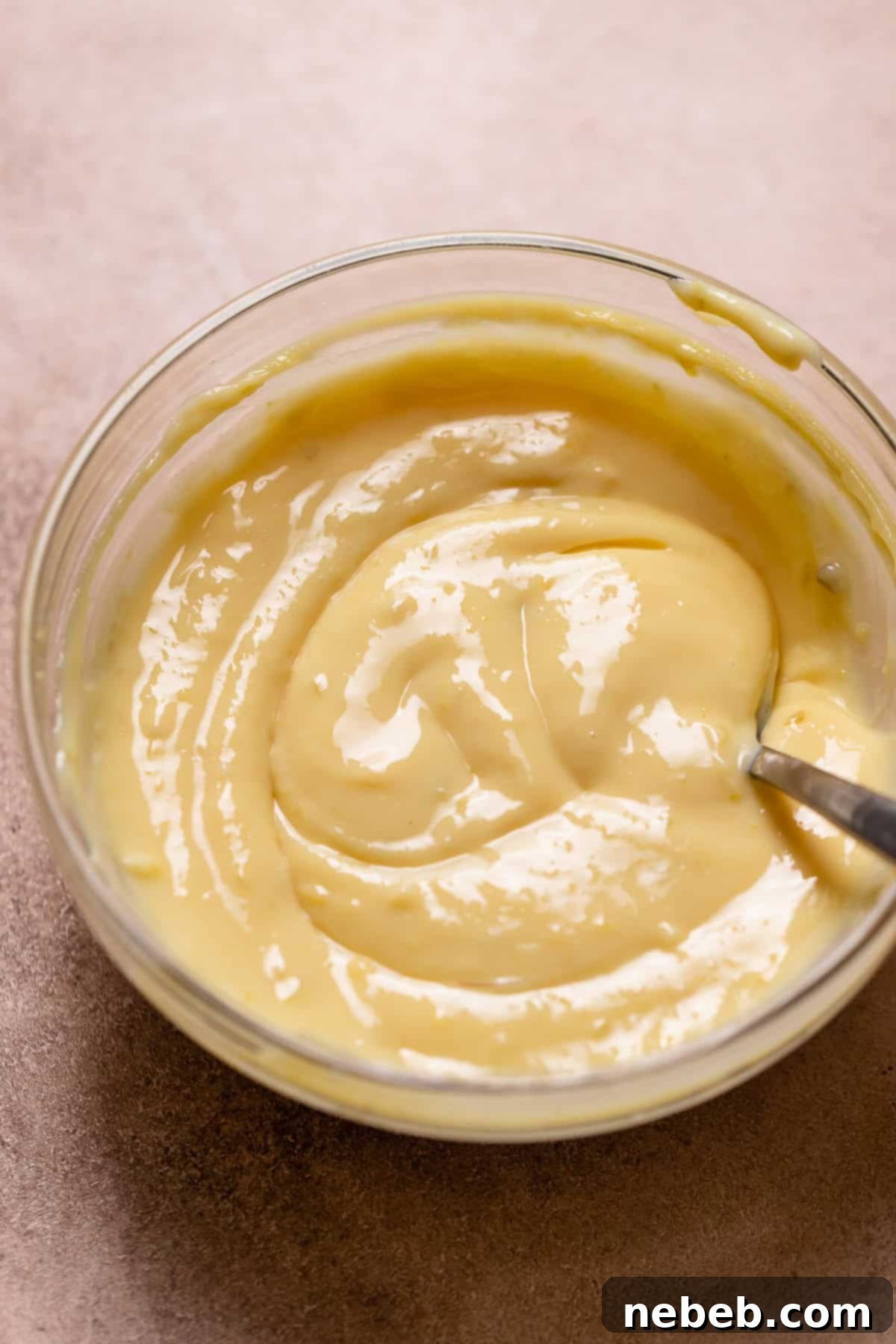 Key lime pie filling in a glass bowl with a spoon.