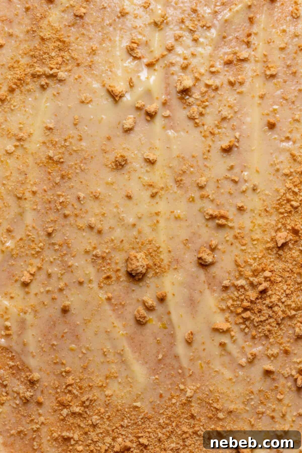 Cinnamon roll dough with key lime pie filling spread across it with graham crackers on top.