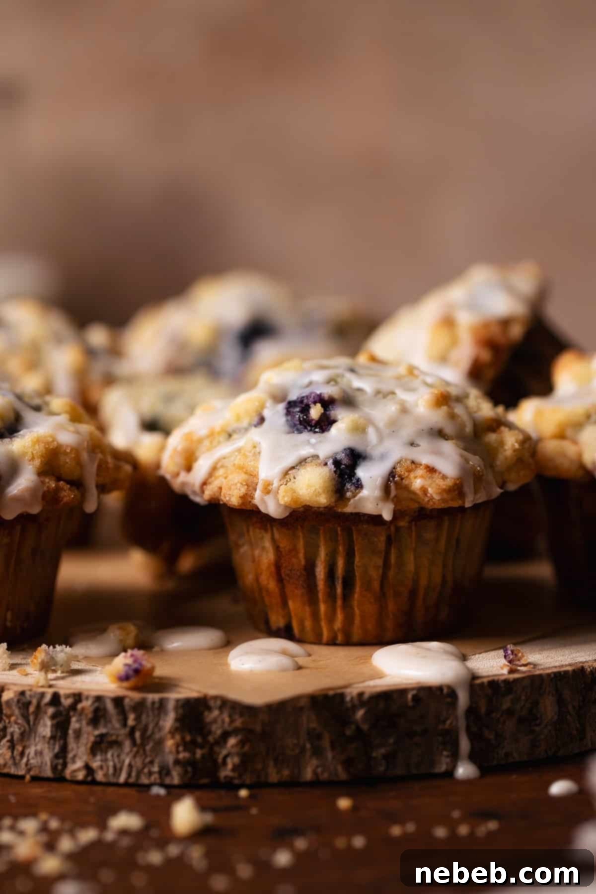Blueberry muffins with crumb topping and vanilla glaze arranged on a beautiful wooden platter, ready to be served.