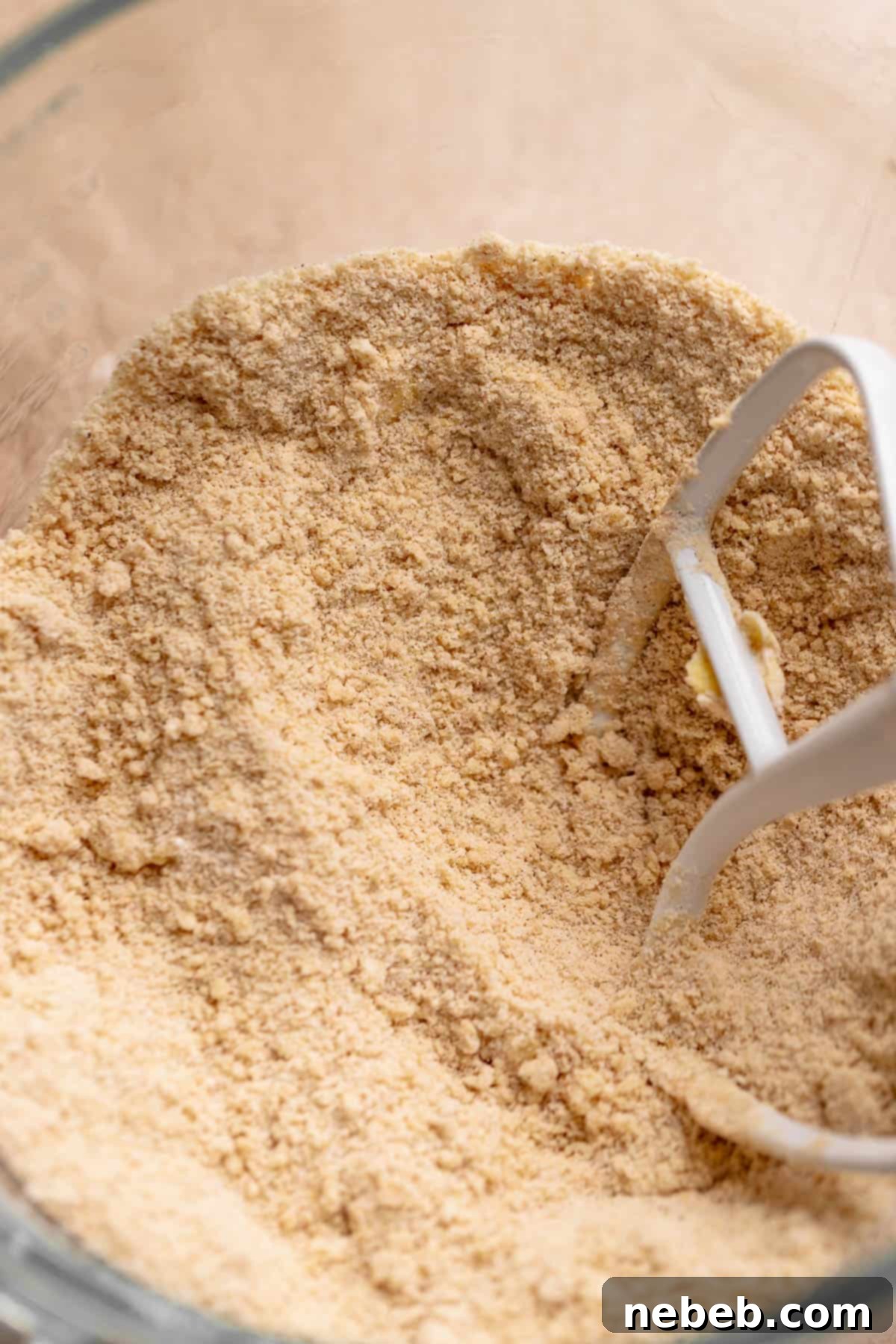 A mixing bowl with the butter mixed into the dry ingredients until it looks crumbly.