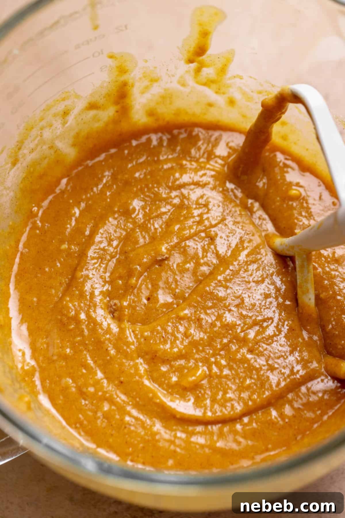 Pumpkin cupcake batter in a glass mixing bowl.