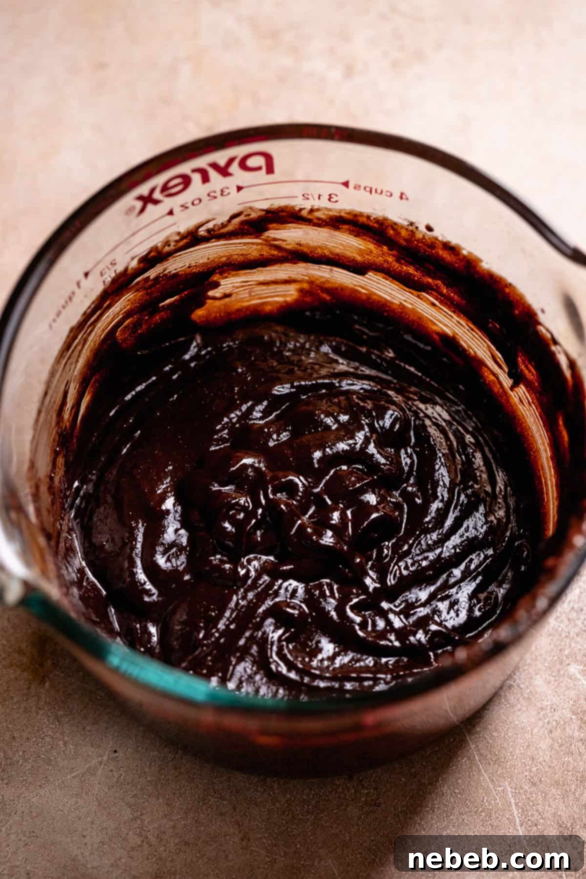 Chocolate filling for the smores bars in a glass measuring cup.