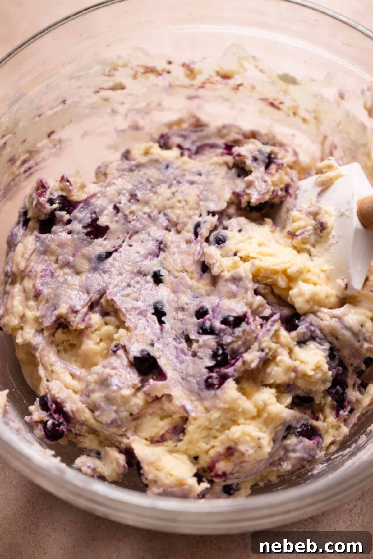 Blueberry cake donut batter in a glass mixing bowl.