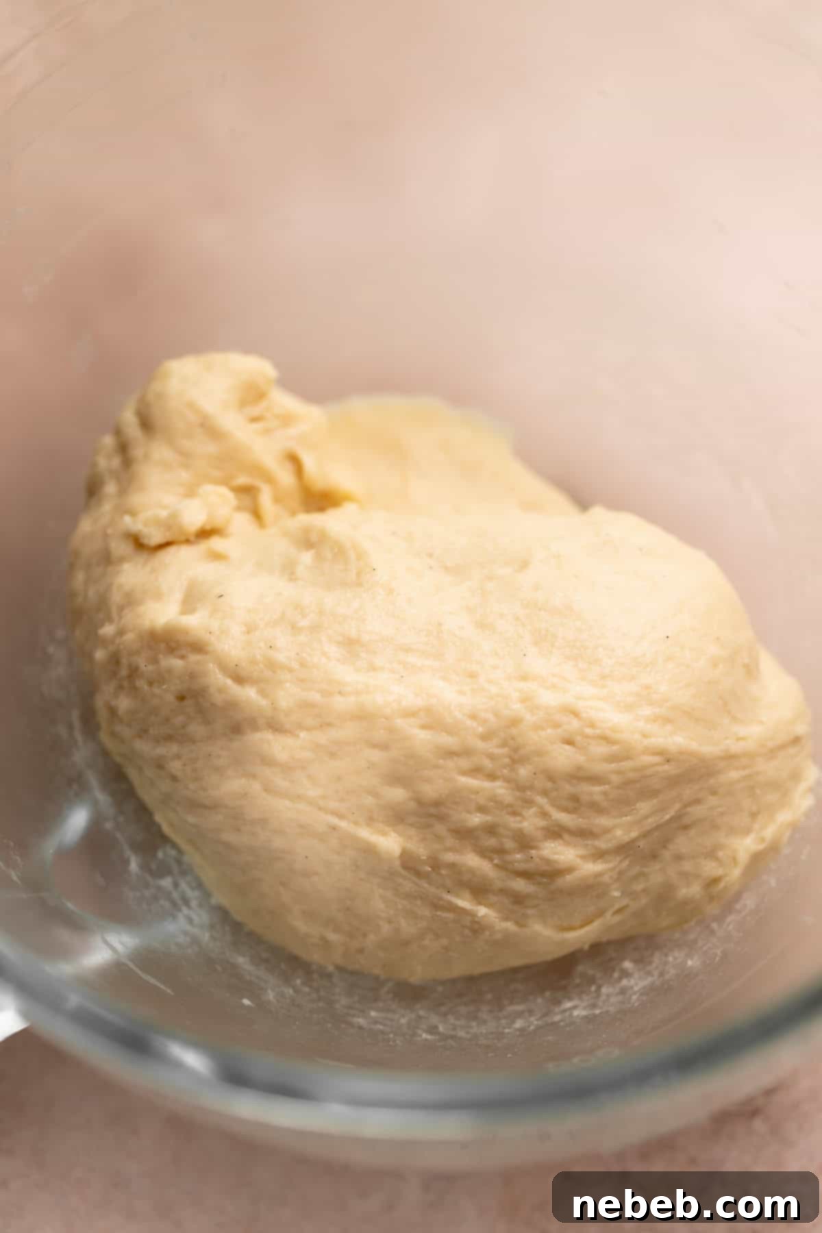 Cinnamon roll dough resting in a mixer bowl before being made into monkey bread.