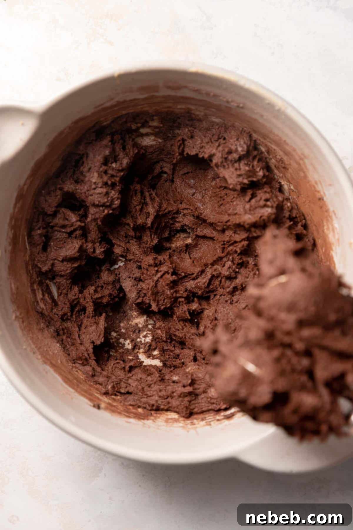 Double chocolate cookie dough in a mixing bowl after dry ingredients and mini chocolate chips have been added.
