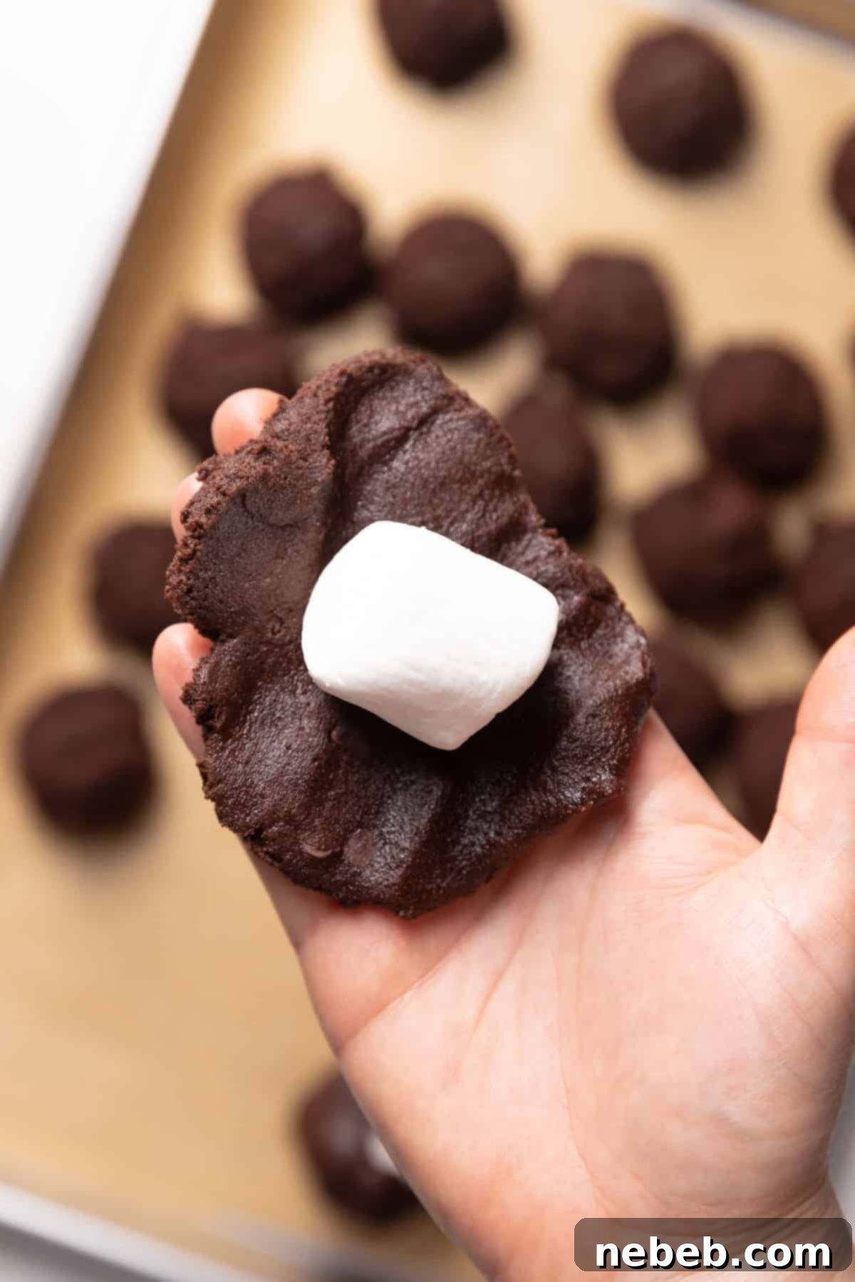 Demonstration of forming cookie dough around a large marshmallow.