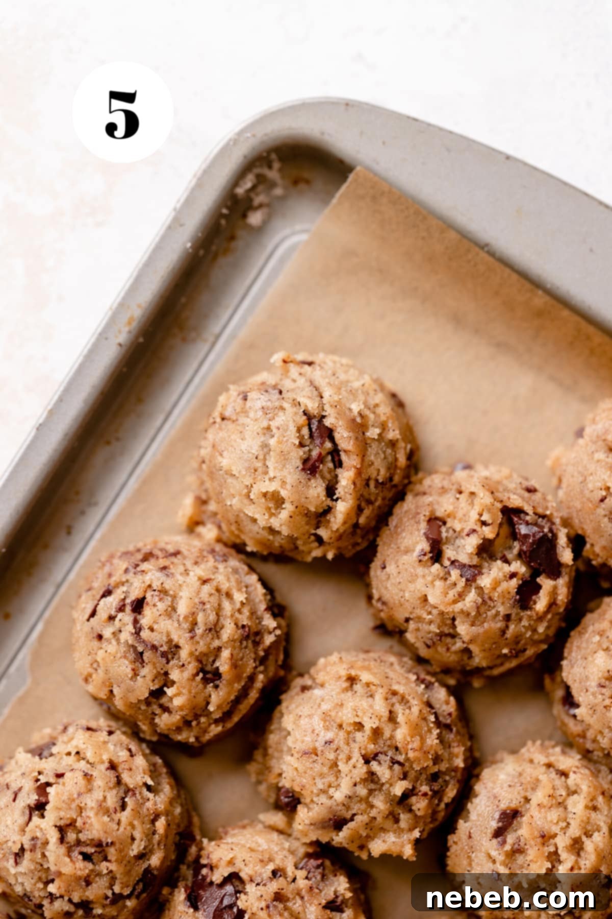 Coffee Kissed Chocolate Chip Cookies 5 Espresso chocolate chip cookie dough balls neatly arranged on a parchment-lined baking tray, ready for chilling.