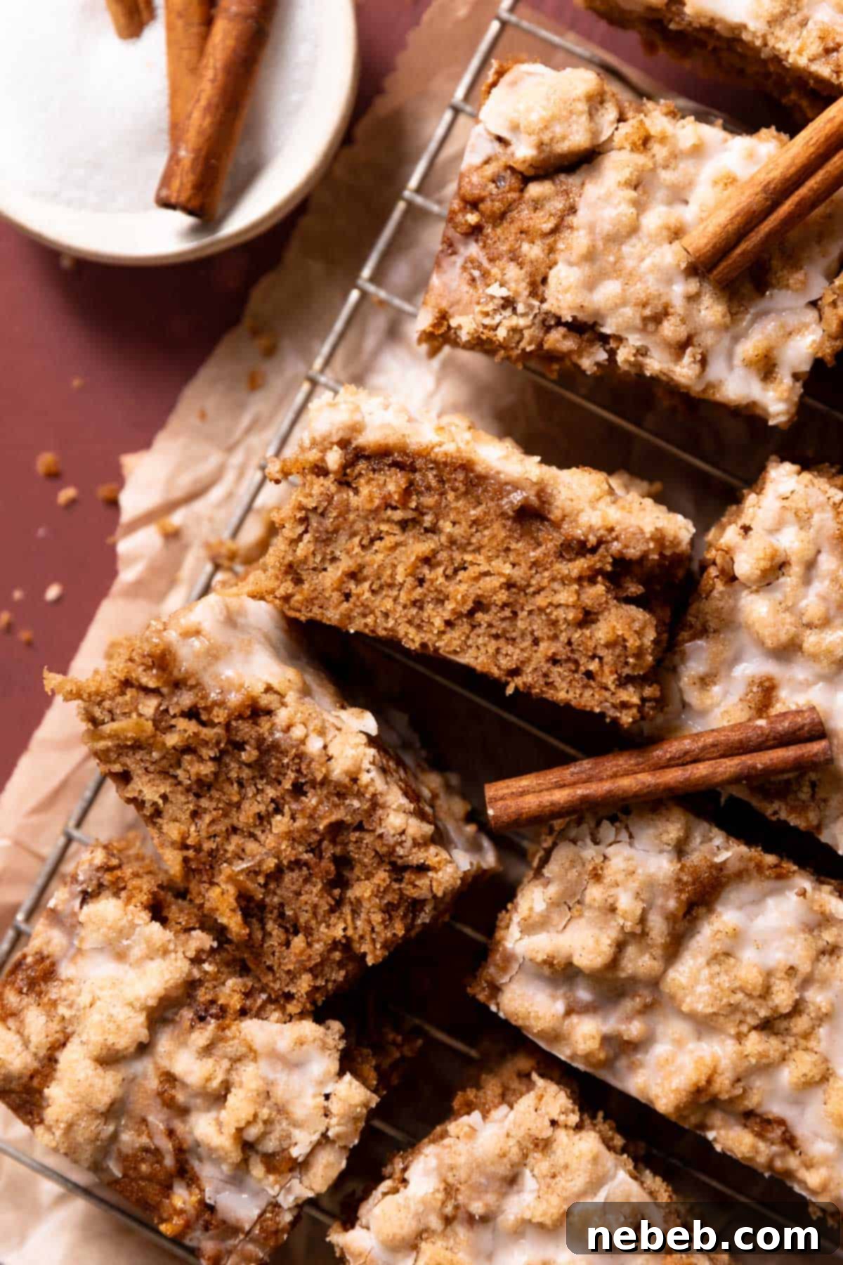 Best Ever Cinnamon Apple Cake 2 Slices of cinnamon apple cake on a wire rack drizzled with vanilla glaze, highlighting its moist texture and inviting appeal.