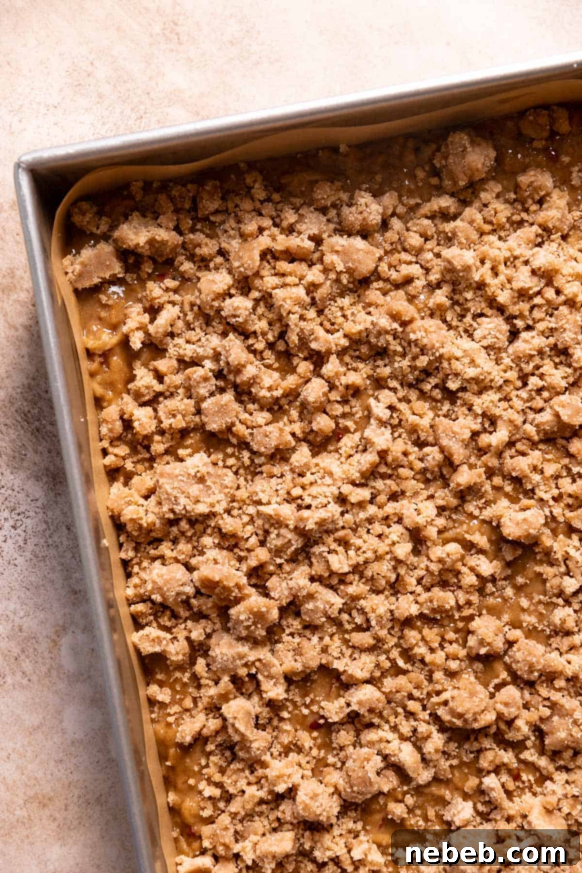 Best Ever Cinnamon Apple Cake 8 A baking pan with the apple cake batter topped with cinnamon crumbs, ready for the oven.
