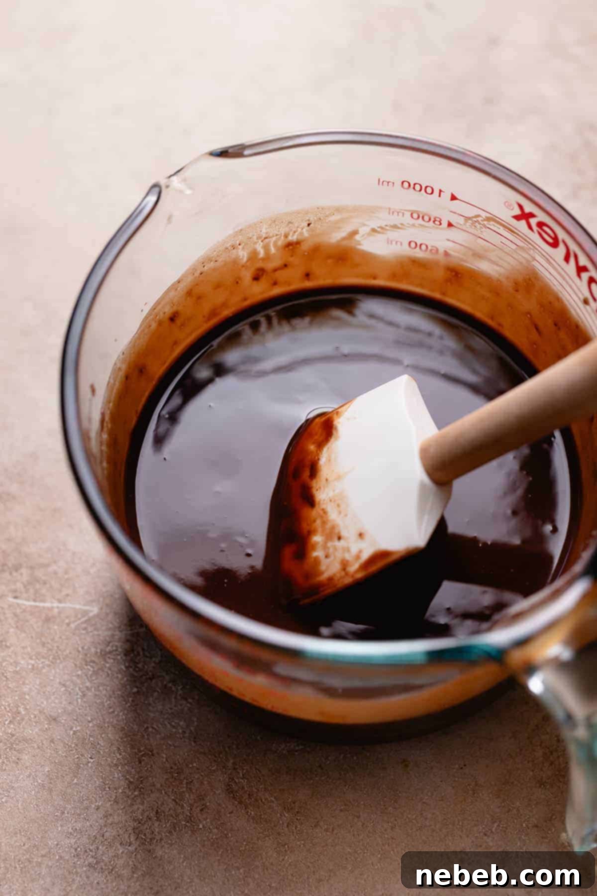 A glass bowl with the melted butter, chocolate, and miso paste.