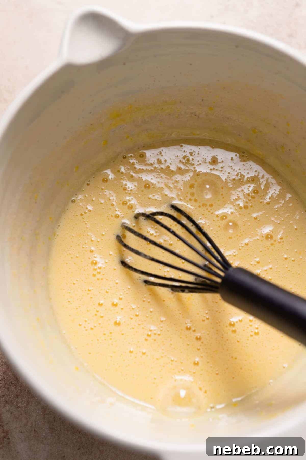 A mixing bowl with the whisked sugar and eggs.