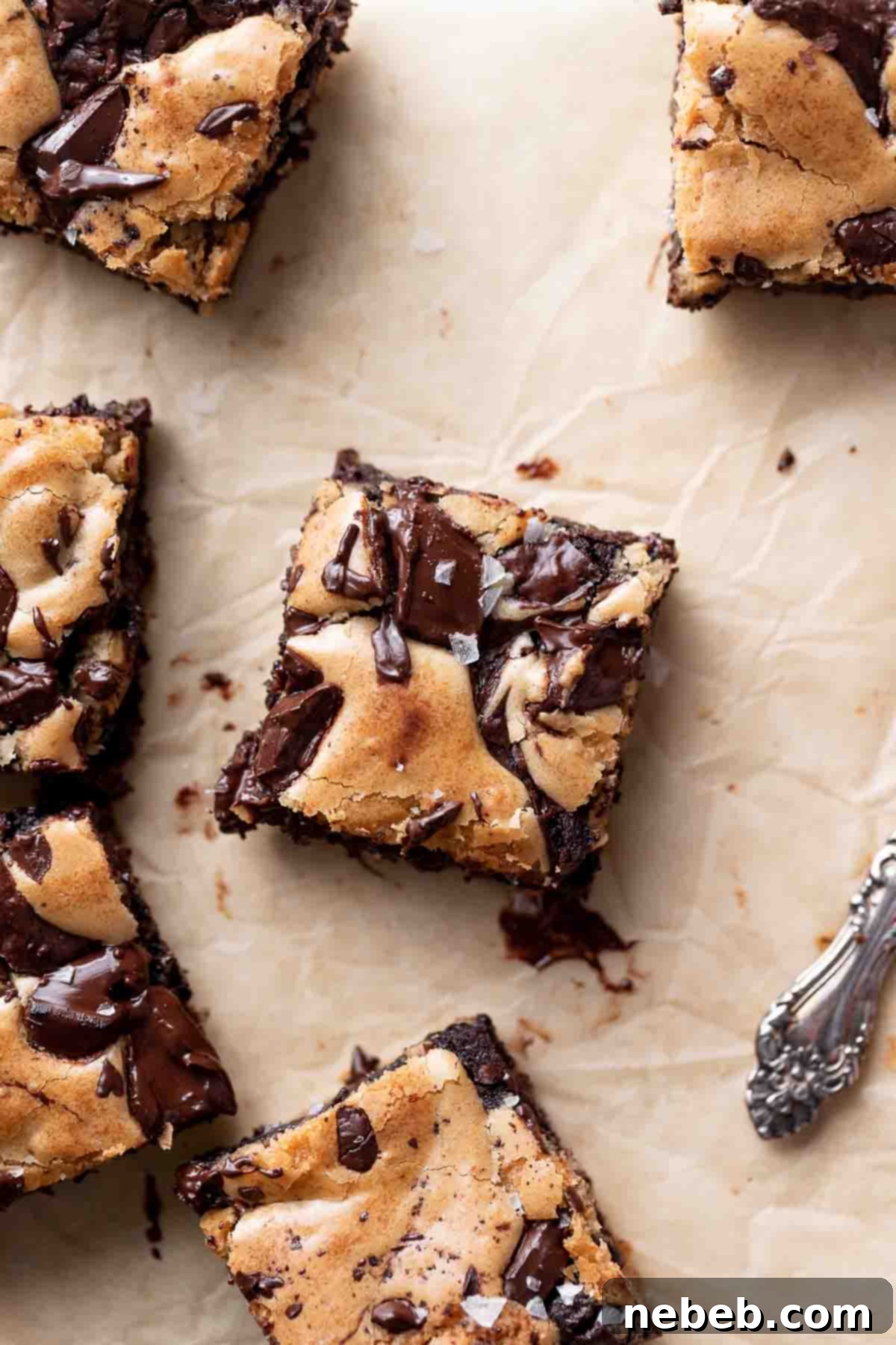 Brownie Blondie Bliss 2 Irresistible brownie blondies beautifully arranged on parchment paper, showcasing their distinct fudgy brownie and gooey blondie layers.