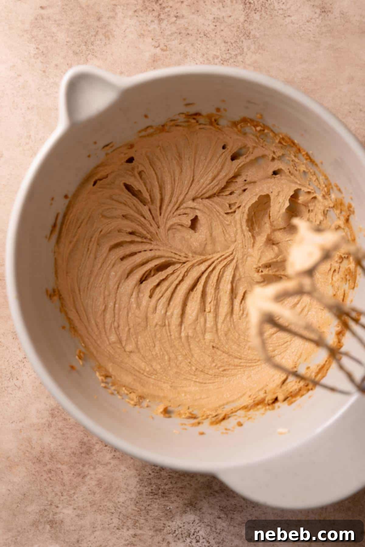 A mixing bowl with the creamed cookie butter, butter, and brown sugar.