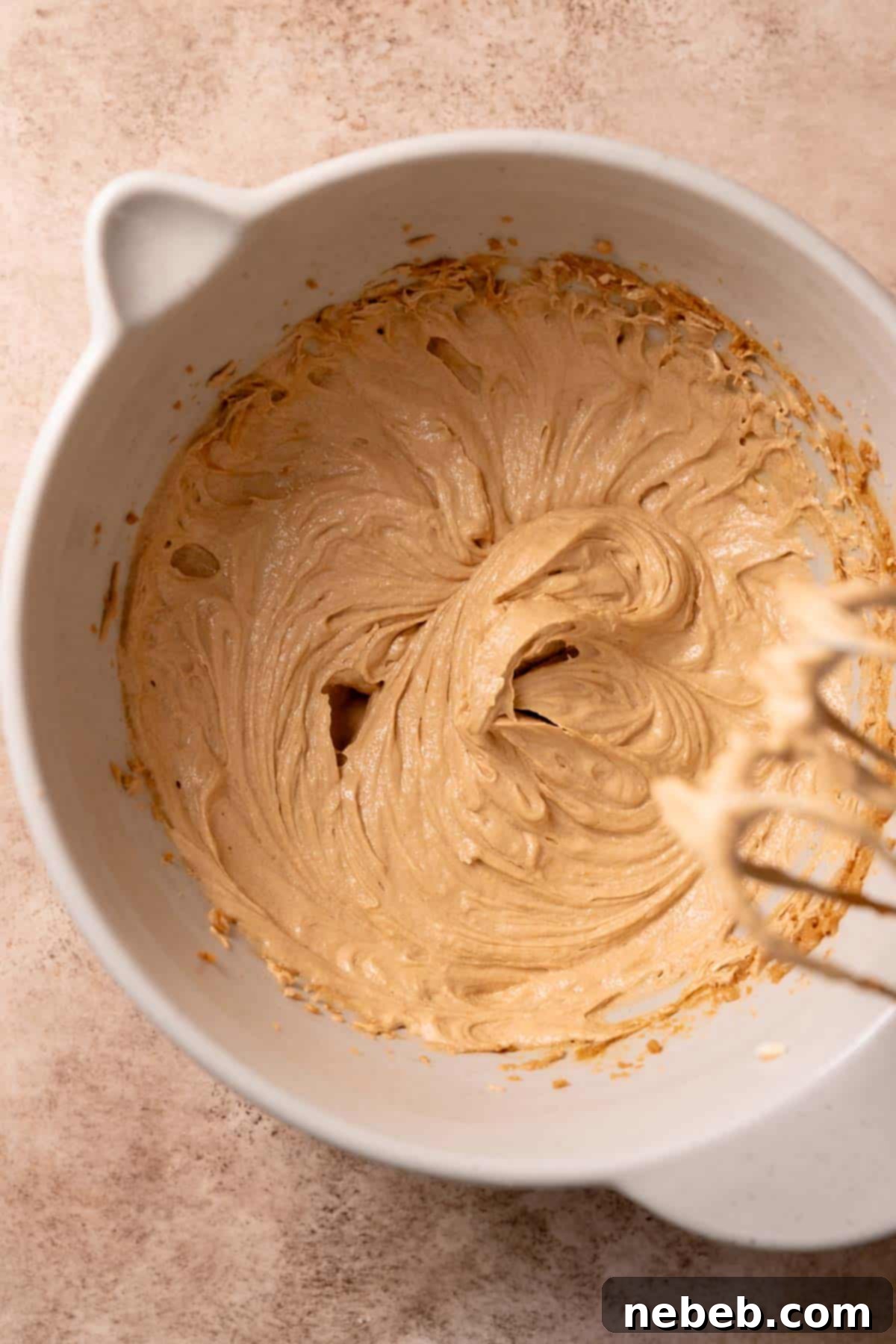 A mixing bowl with the creamed butter and sugar with the egg mixed into it.