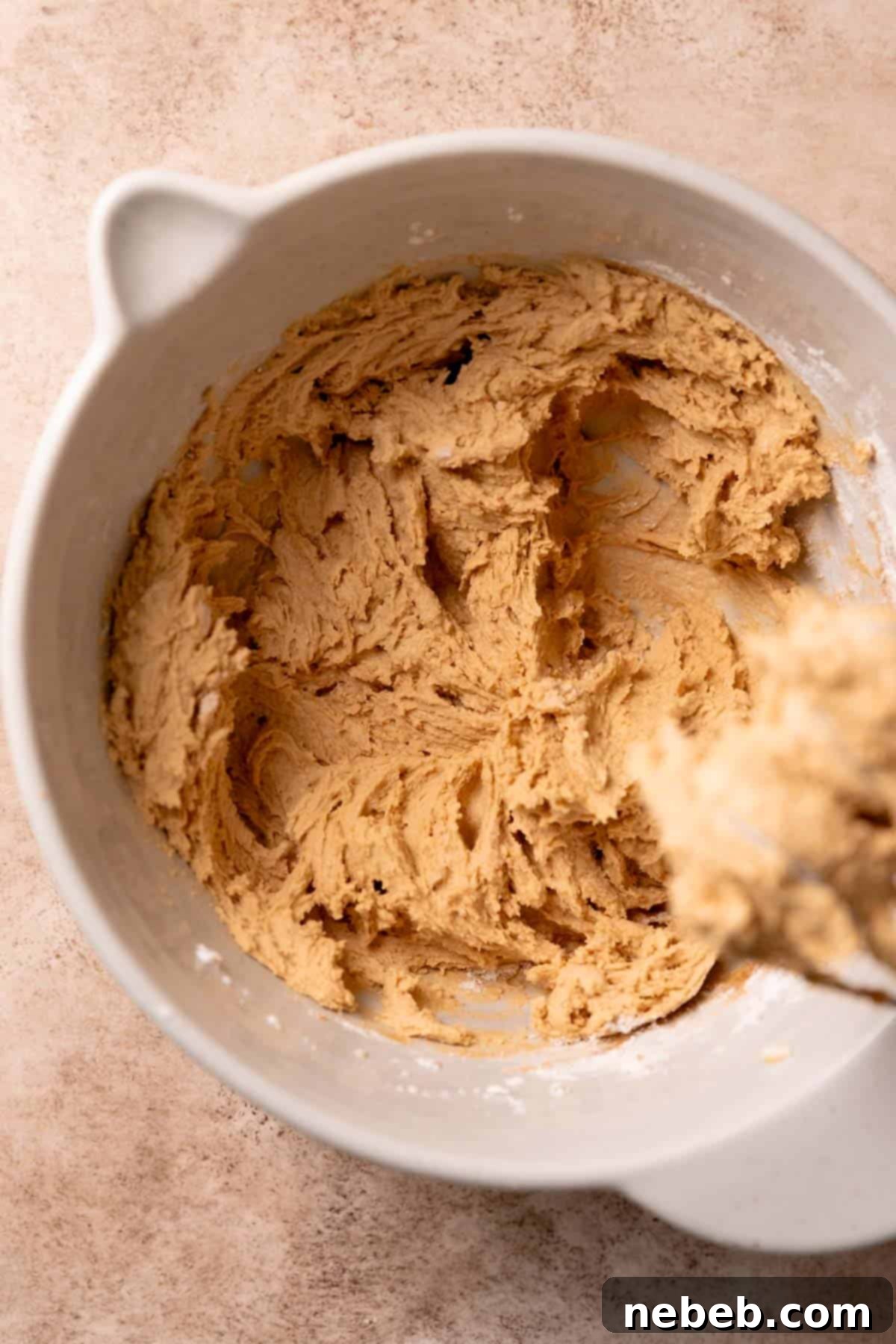 A mixing bowl with the cookie butter cookie dough after mixing in the dry ingredients.