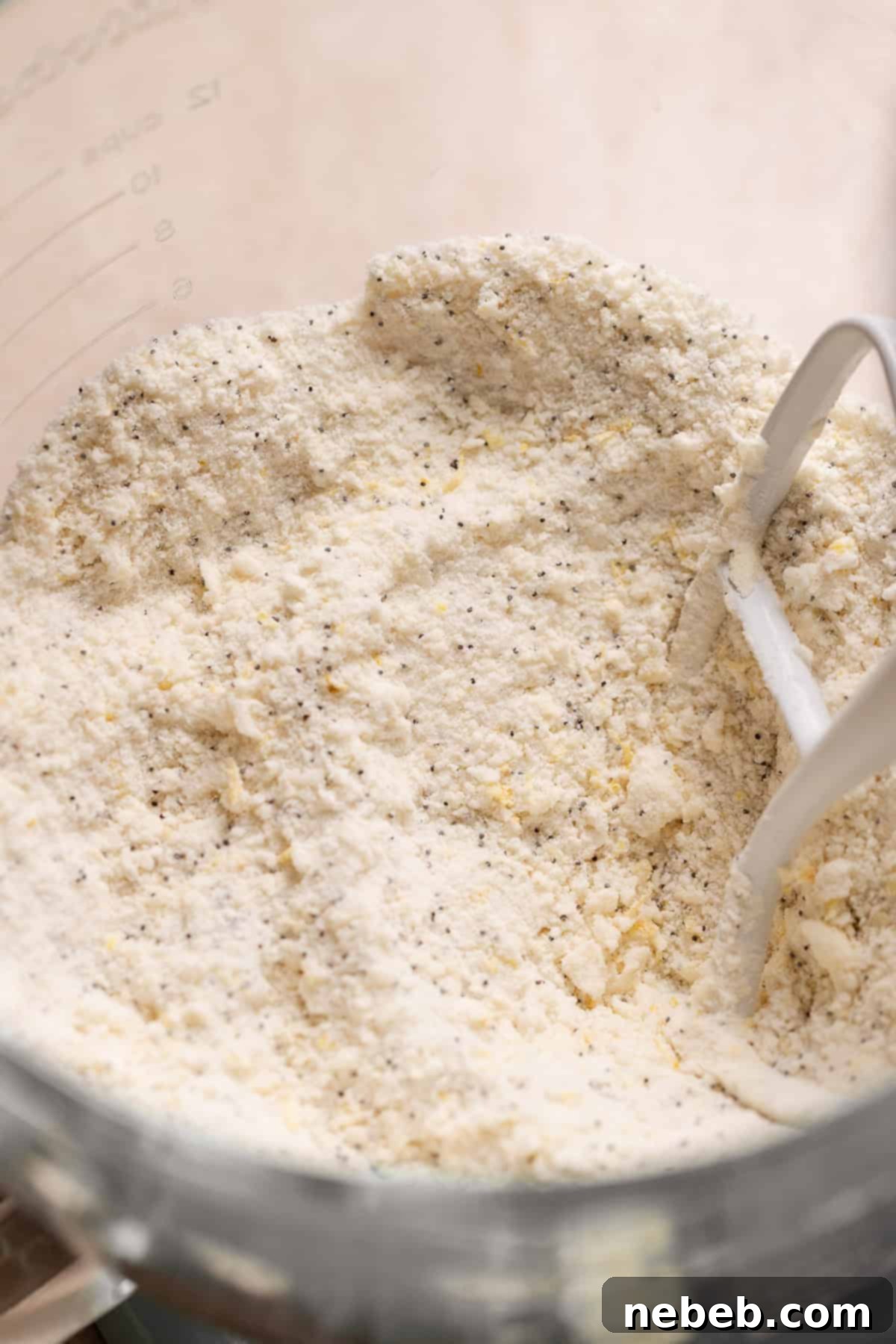 A mixing bowl showing the initial mixture of butter and dry ingredients, resembling coarse sand.