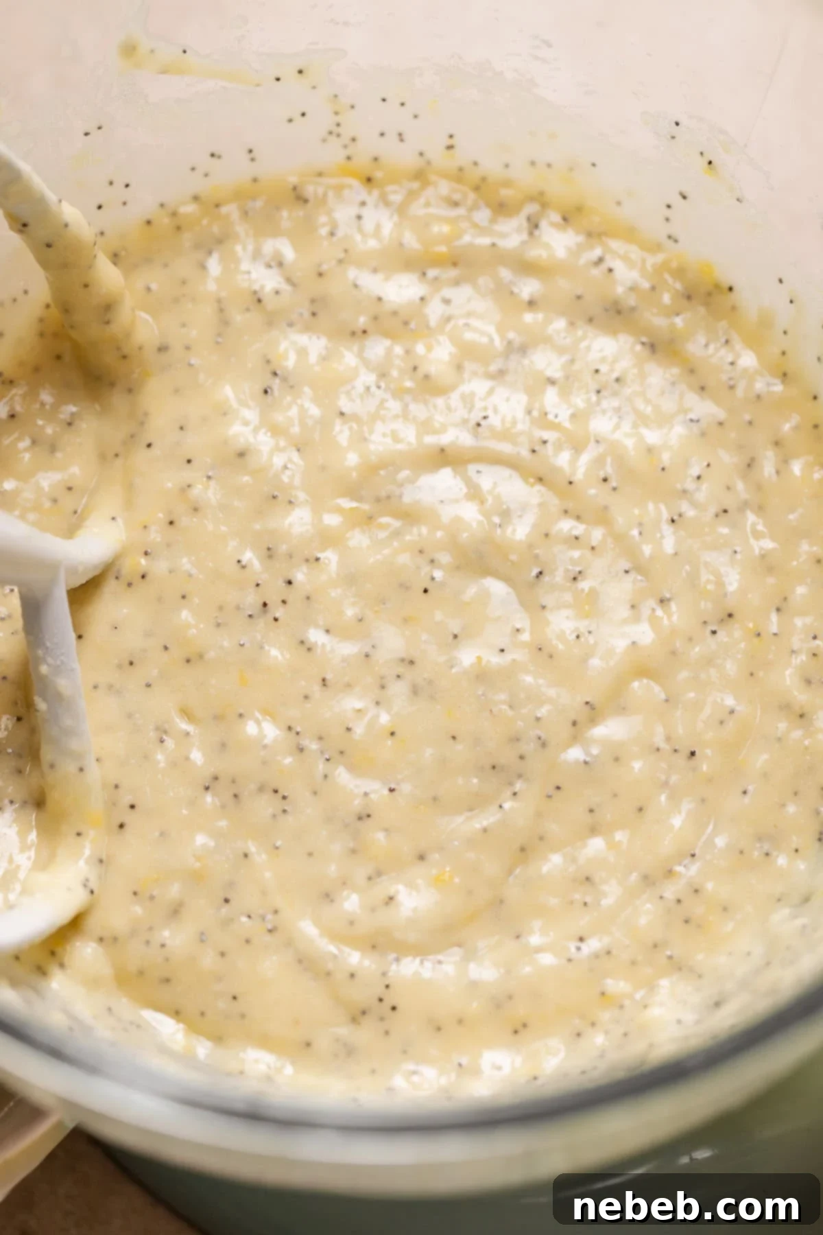 Lemon poppy seed cupcake batter in a large mixing bowl, showing its thick and fluffy consistency.