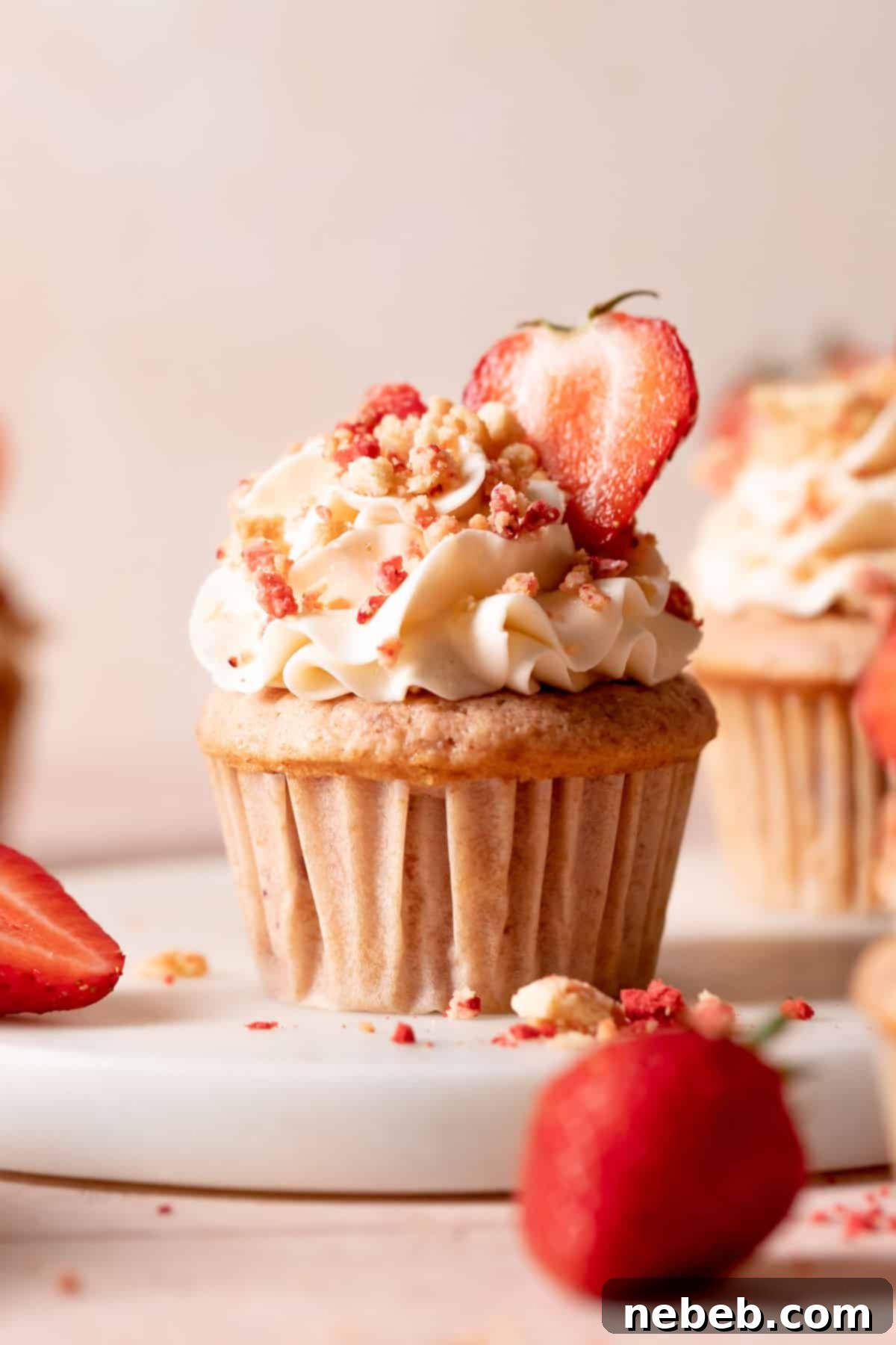 Golden Crunch Strawberry Cupcakes 2 Delicious strawberry crunch cupcake with creamy vanilla frosting and crunchy topping on a white background, perfect for a summer dessert.