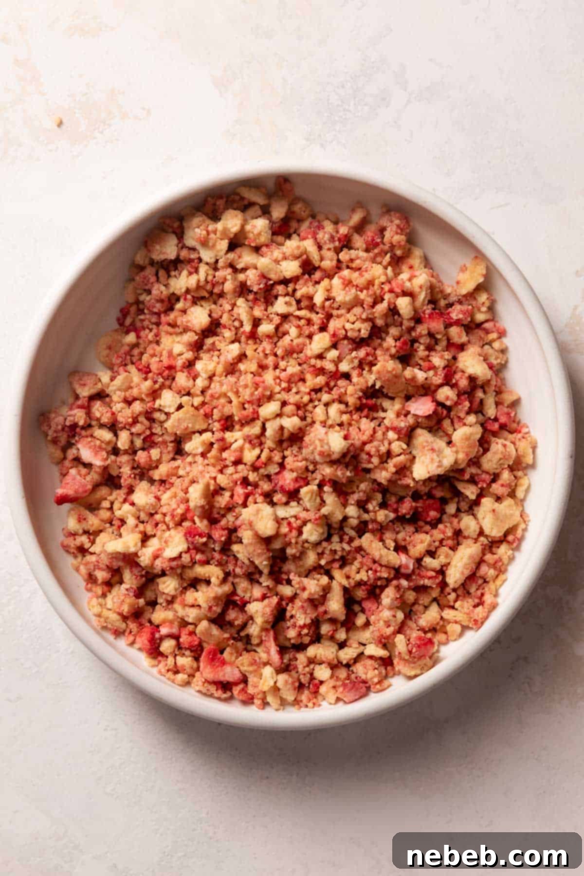 Golden Crunch Strawberry Cupcakes 4 Bowl of strawberry crunch topping made with Golden Oreos and freeze-dried strawberries, ready to garnish cupcakes.