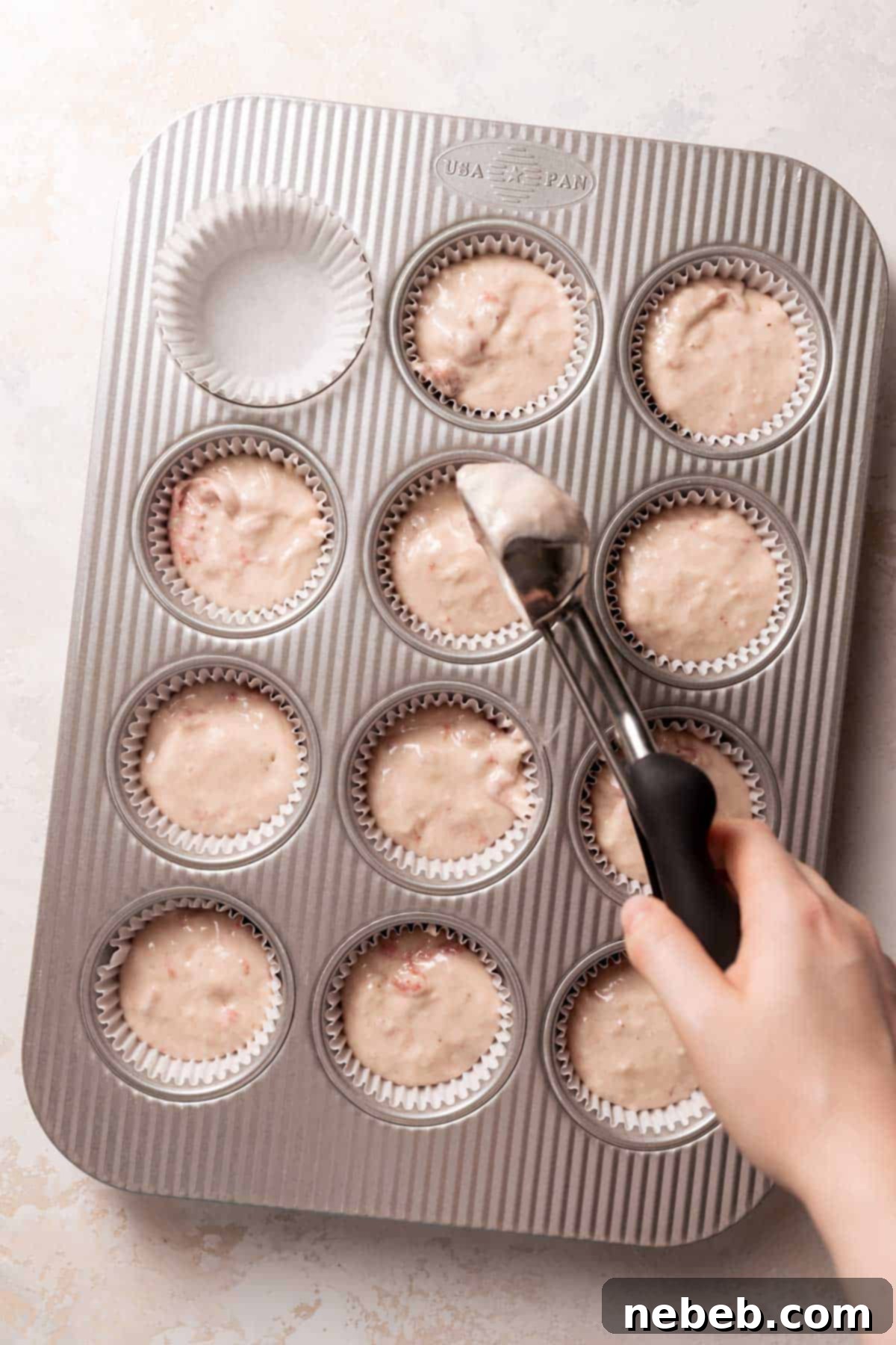 Golden Crunch Strawberry Cupcakes 8 Filling cupcake liners with the moist strawberry cupcake batter using an ice cream scoop for even portions.