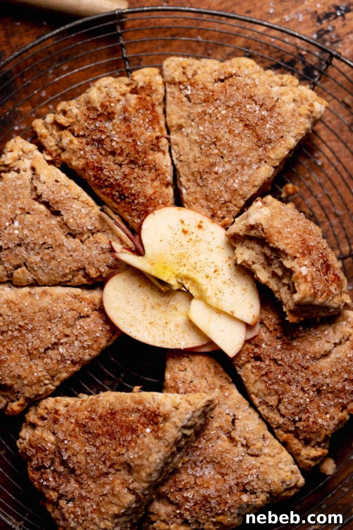 Apple scones on a wire rack with a few fresh apple slices on top.