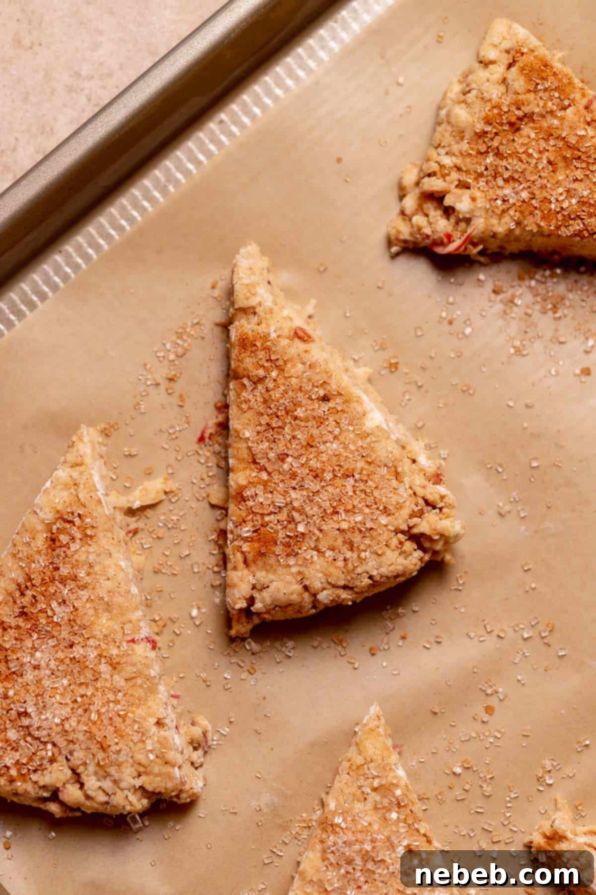 Apple scones on a baking sheet sprinkled with cinnamon sugar before baking.