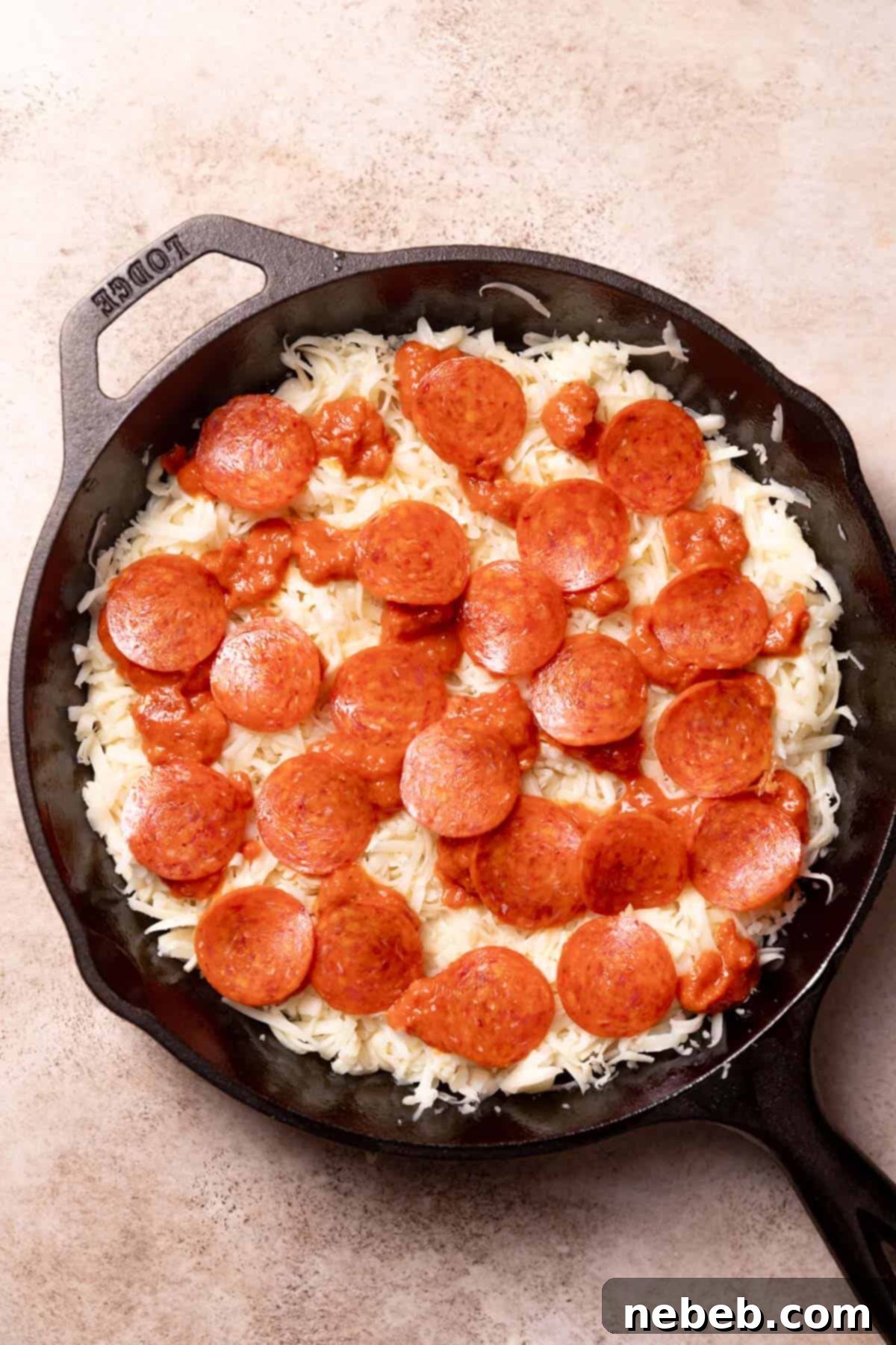 cast iron pizza with pepperoni before baking.