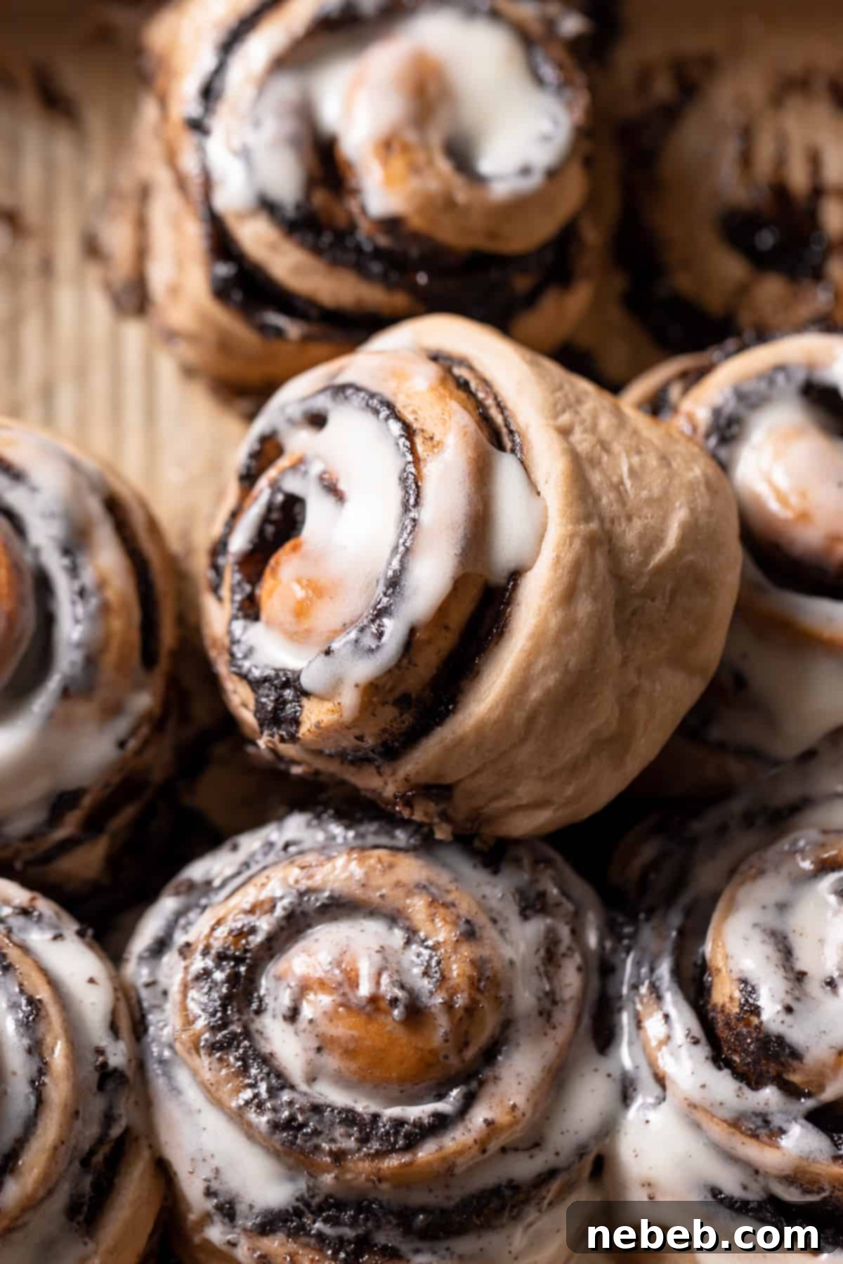 Close-up of freshly baked cookies and cream cinnamon rolls generously covered with cream cheese icing, ready to be served.