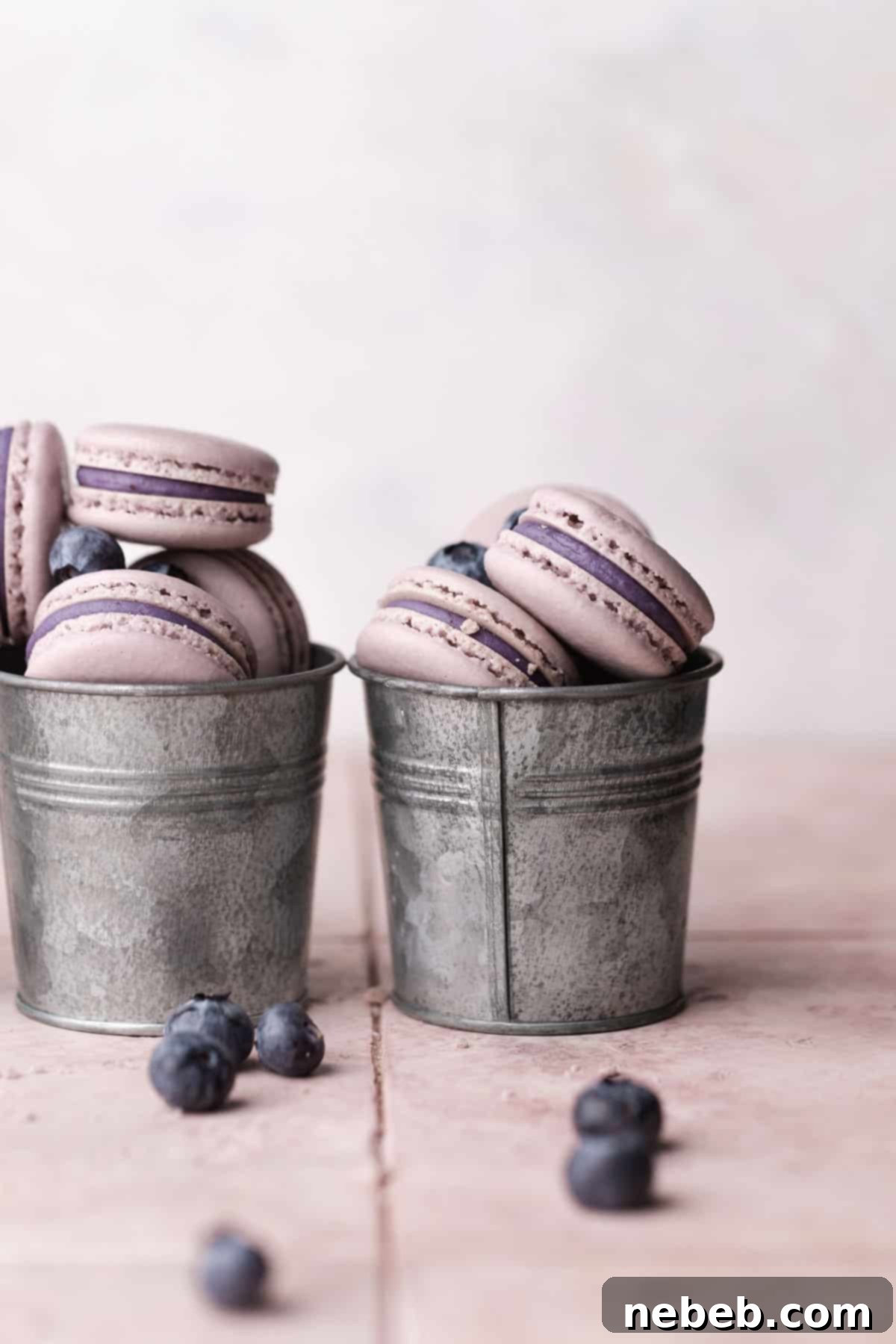 two metal cups full of blueberry macarons.