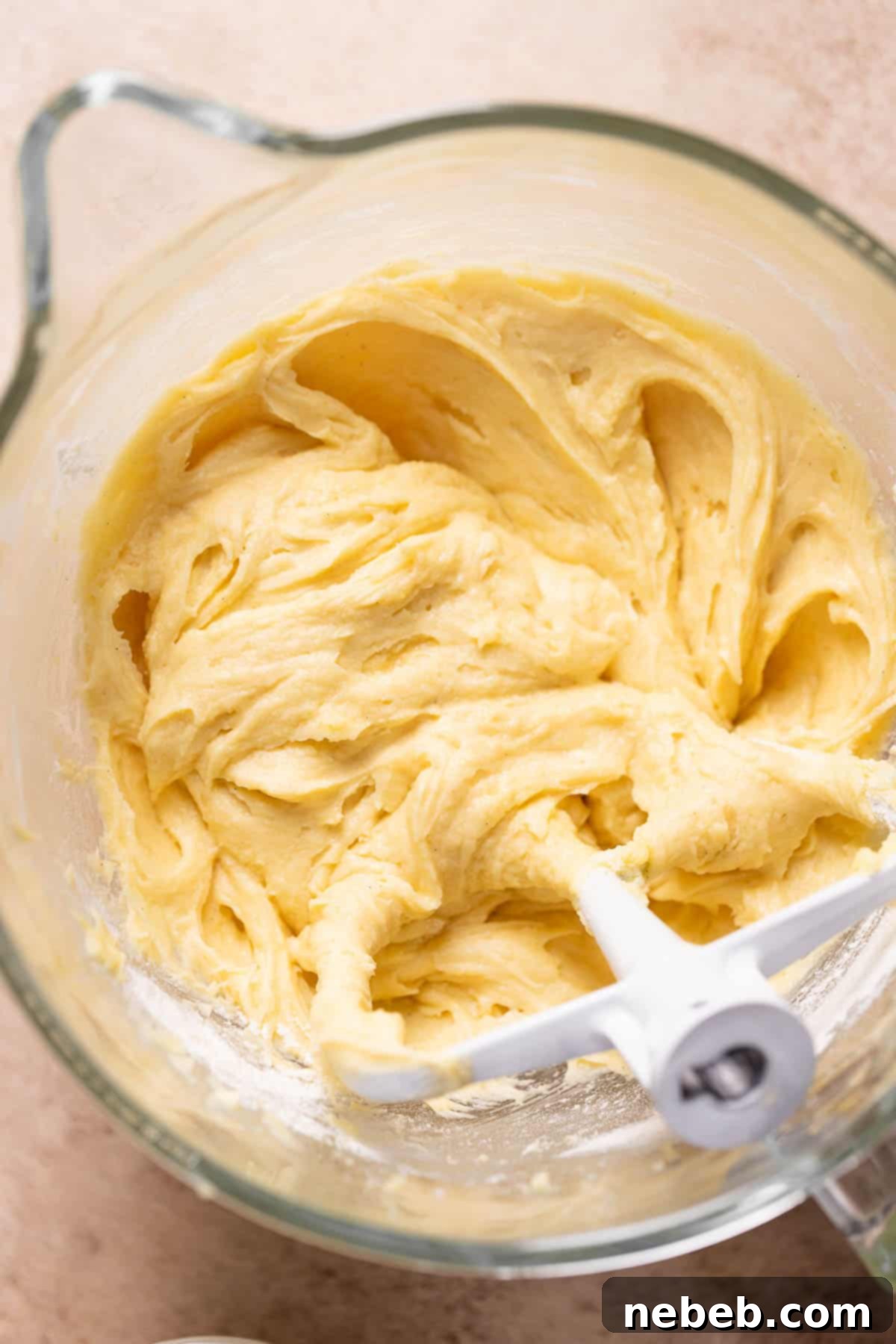 A glass mixing bowl containing the perfectly smooth vanilla cake batter.