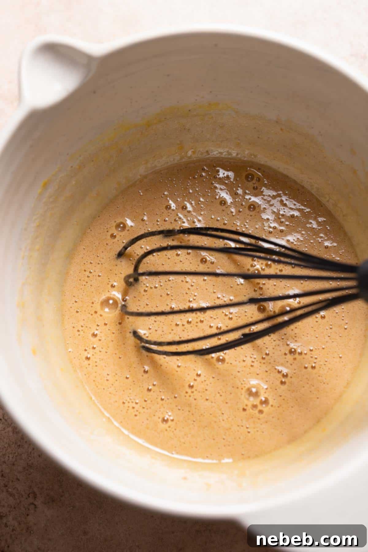 A mixing bowl with the whisked sugar and eggs.