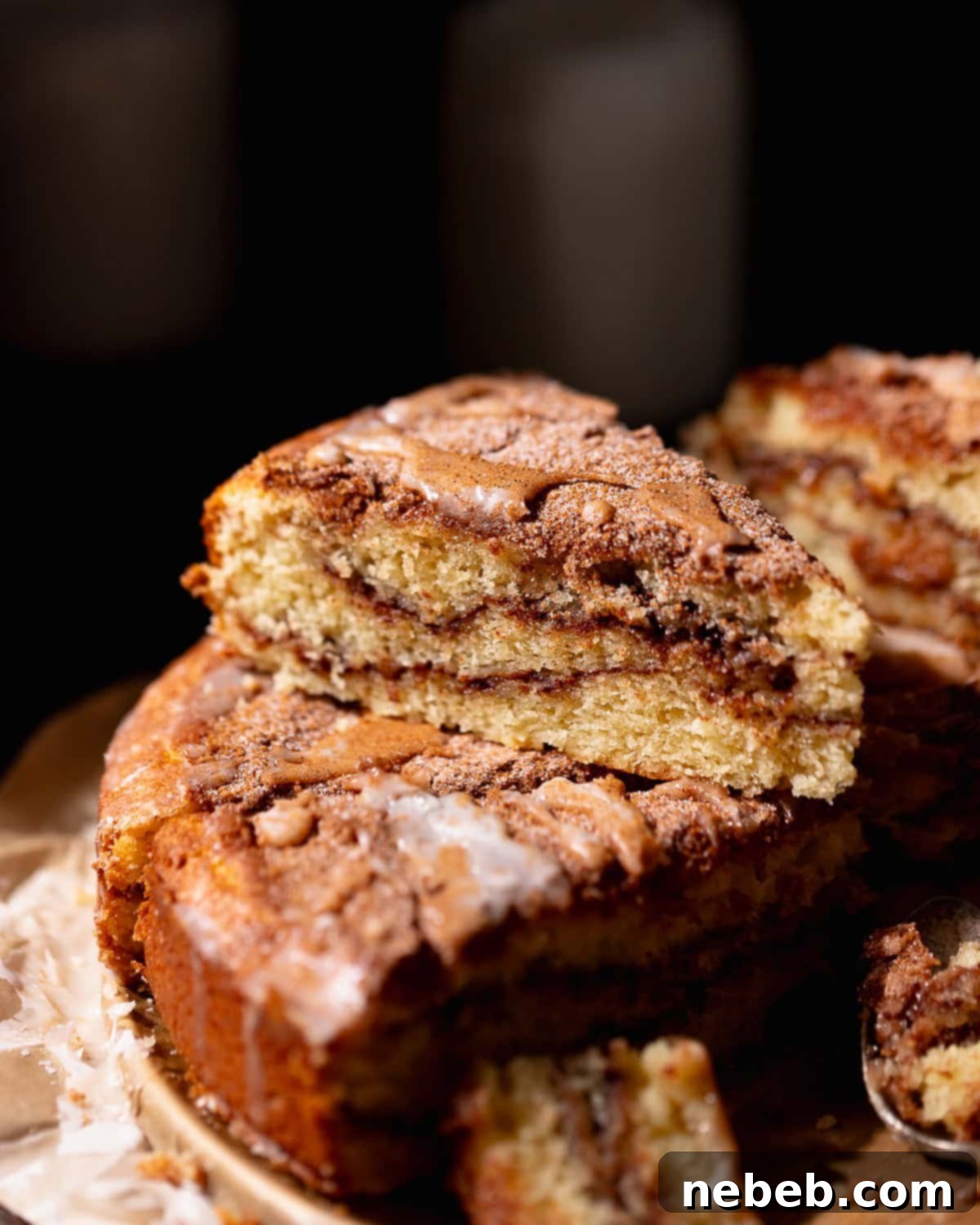 A slice of cinnamon swirl coffee cake stacked on top of other slices of cake.
