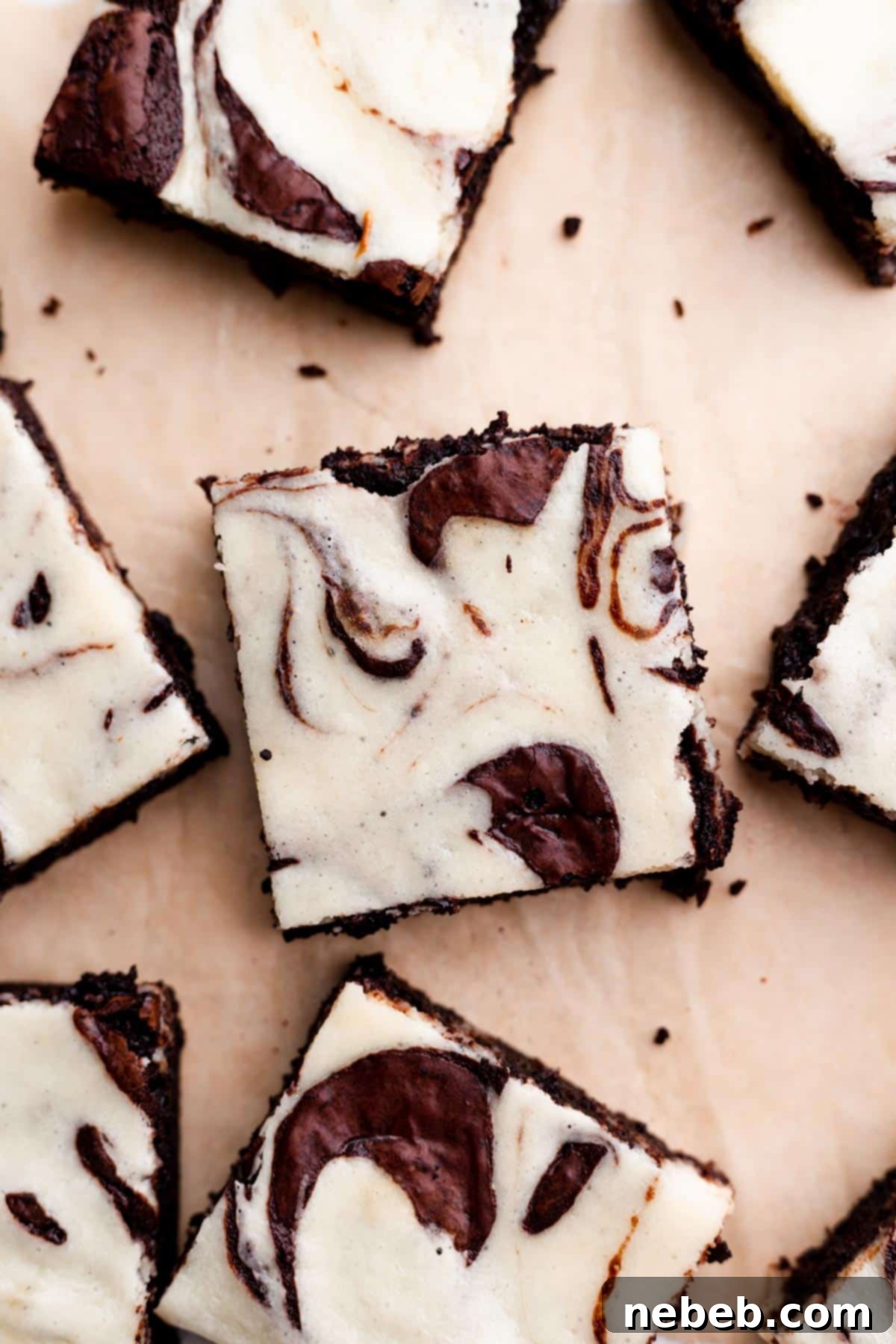 marble brownies cut into squares on a piece of parchment paper.