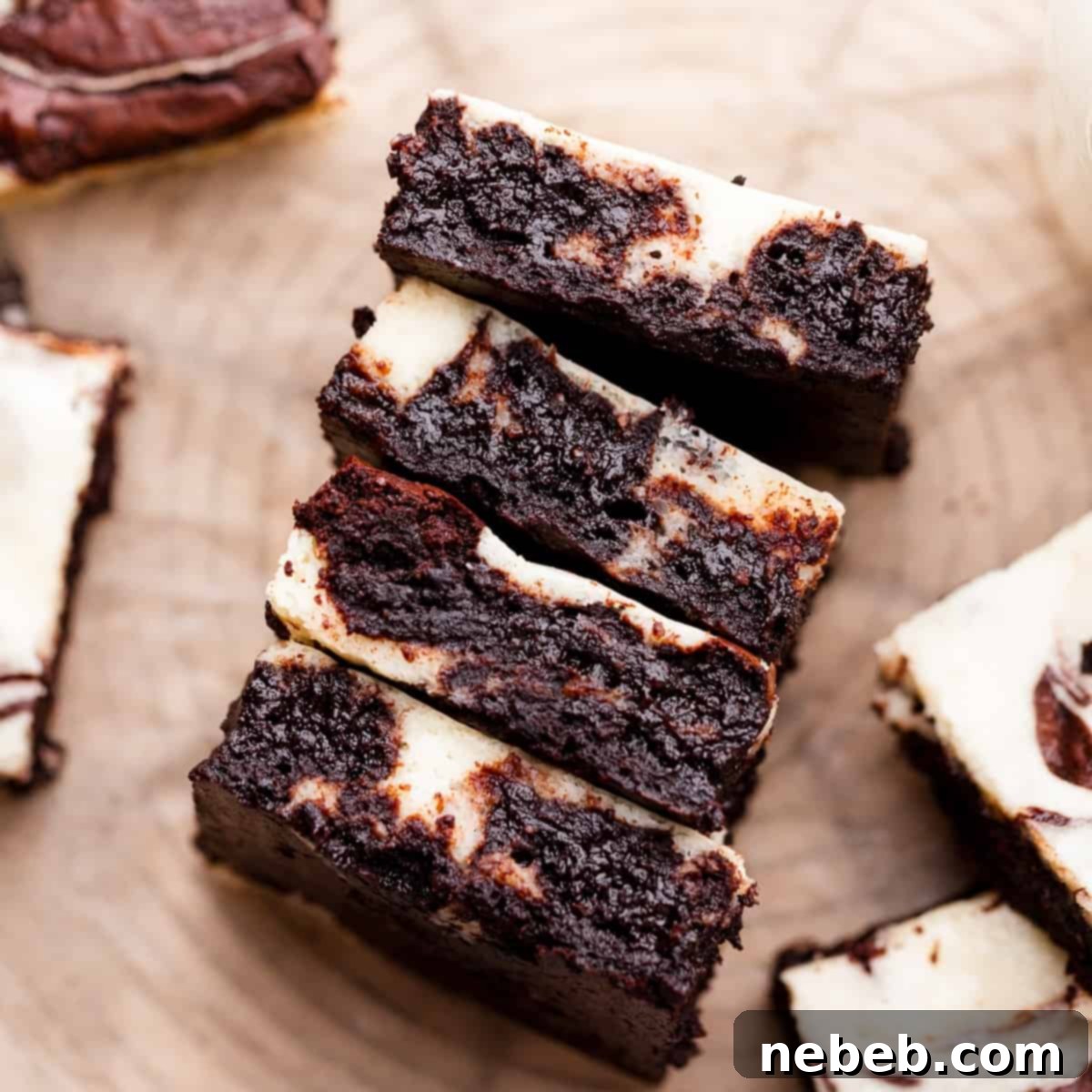 four marble brownies stacked to show the cheesecake and brownie swirl.