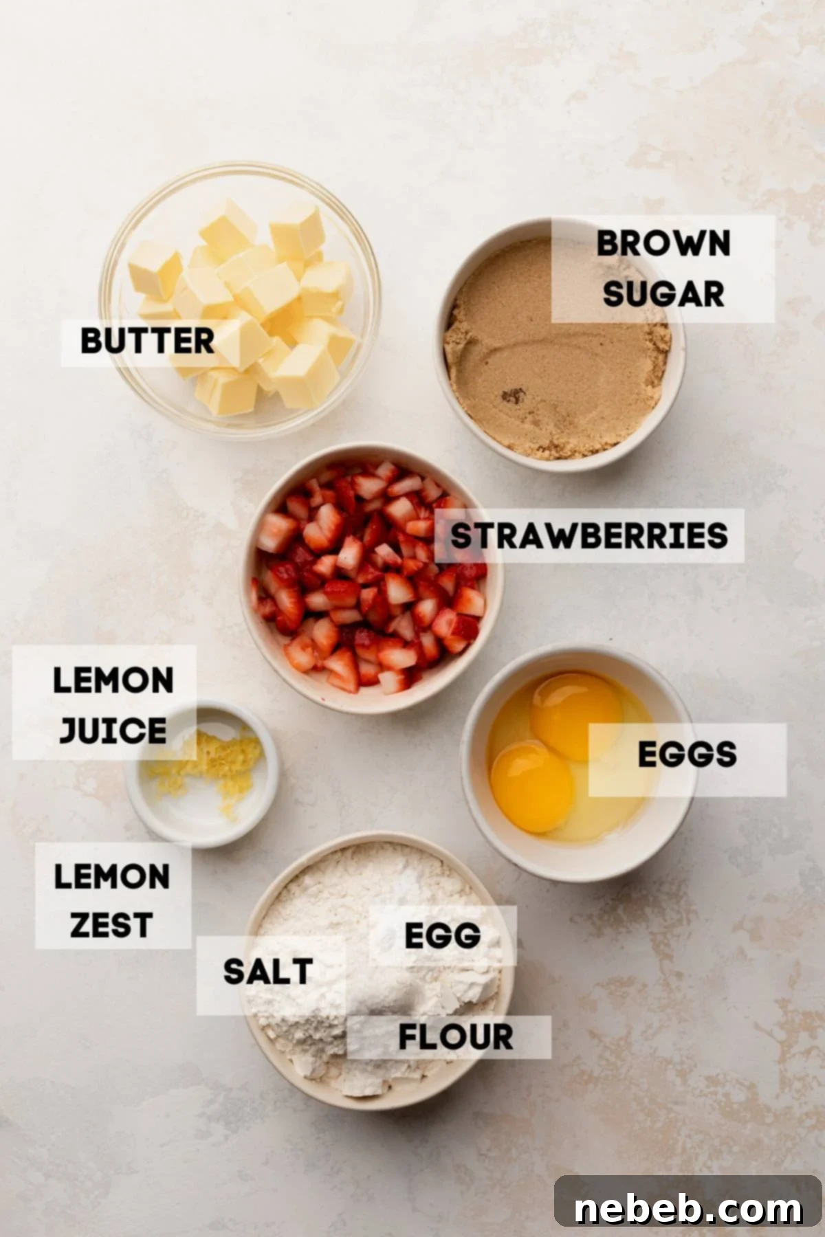 A flat lay image showing all the fresh ingredients needed to make delicious strawberry lemon blondies, including fresh strawberries, lemons, butter, sugar, and flour.