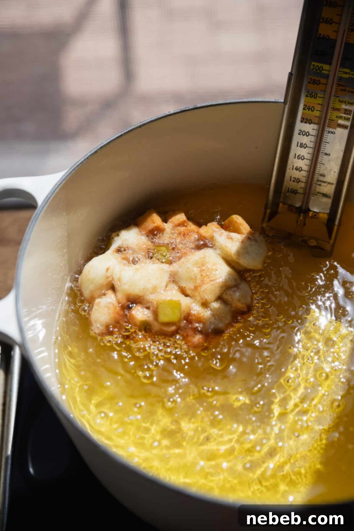 Homemade Apple Fritters So Good You Will Skip The Bakery 9 An apple fritter frying in hot oil.